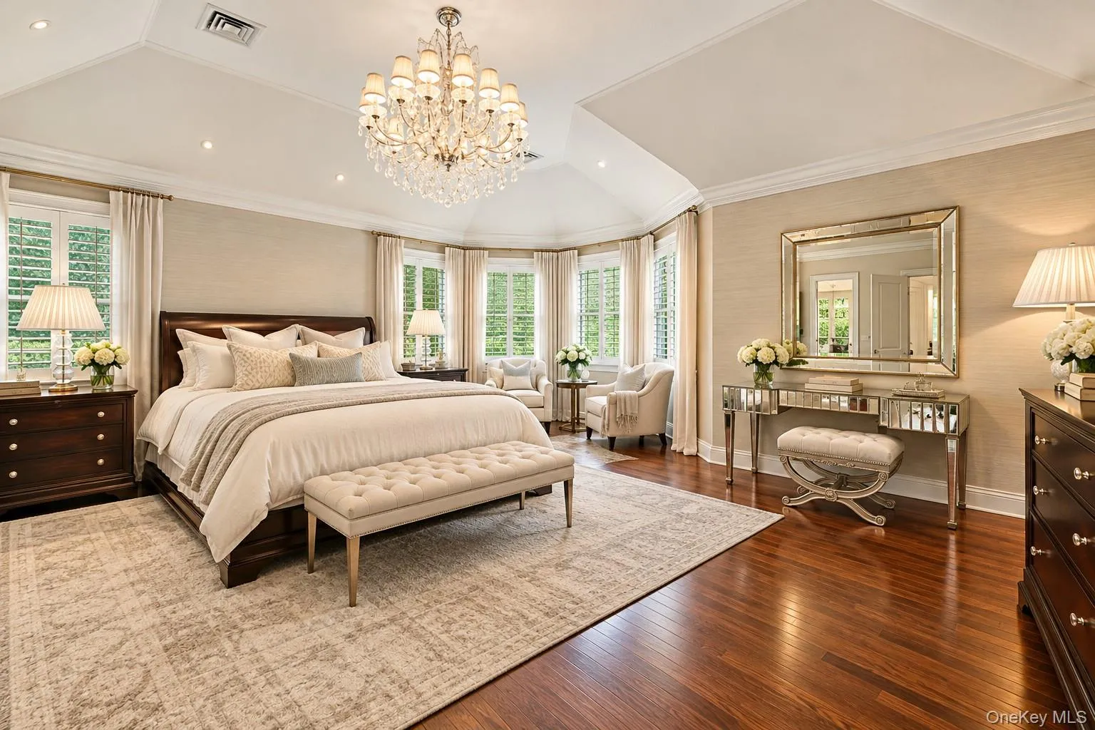Tray ceiling with a crystal chandelier, wood-finish flooring, and a bay window Tray ceiling with a crystal chandelier, wood-finish flooring, and a bay window