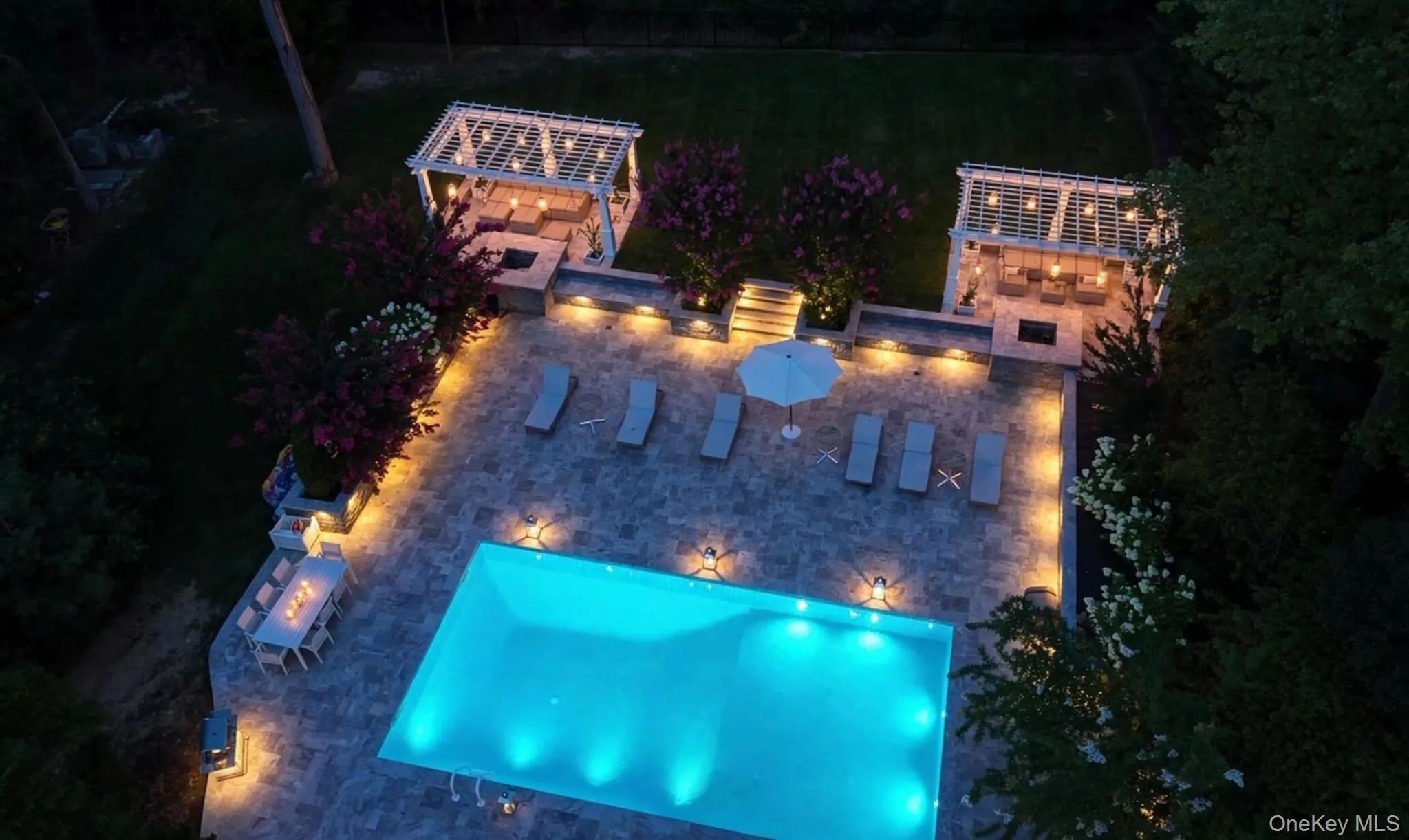 Rectangular swimming pool surrounded by a paver patio with integrated lighting Rectangular swimming pool surrounded by a paver patio with integrated lighting