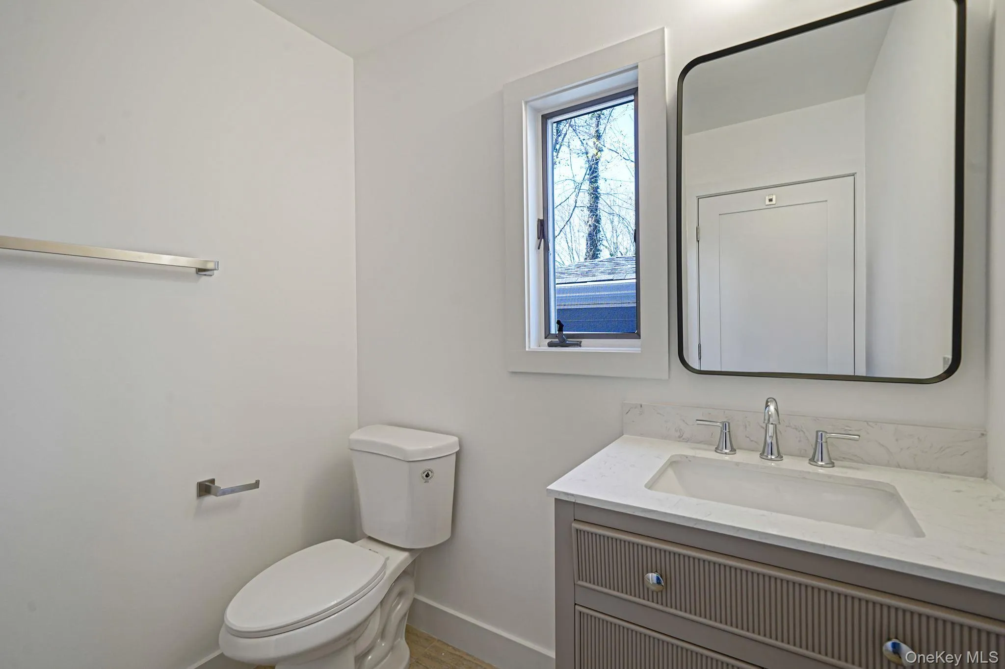 Bathroom featuring vanity, baseboards, and toilet Bathroom featuring vanity, baseboards, and toilet