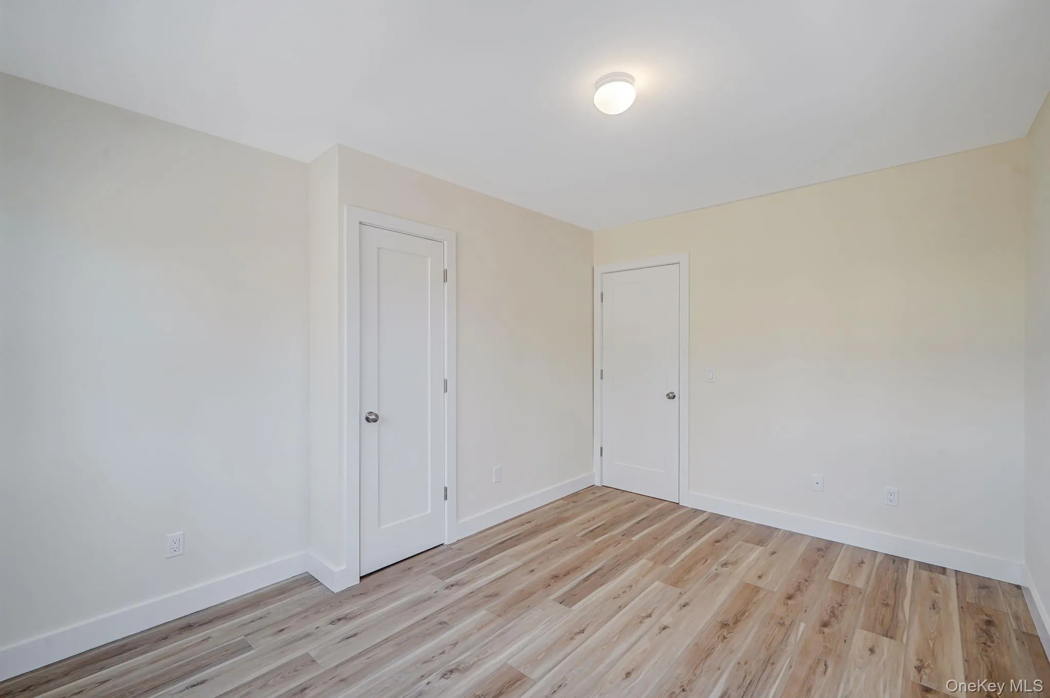 Unfurnished room featuring baseboards and light wood-type flooring Unfurnished room featuring baseboards and light wood-type flooring
