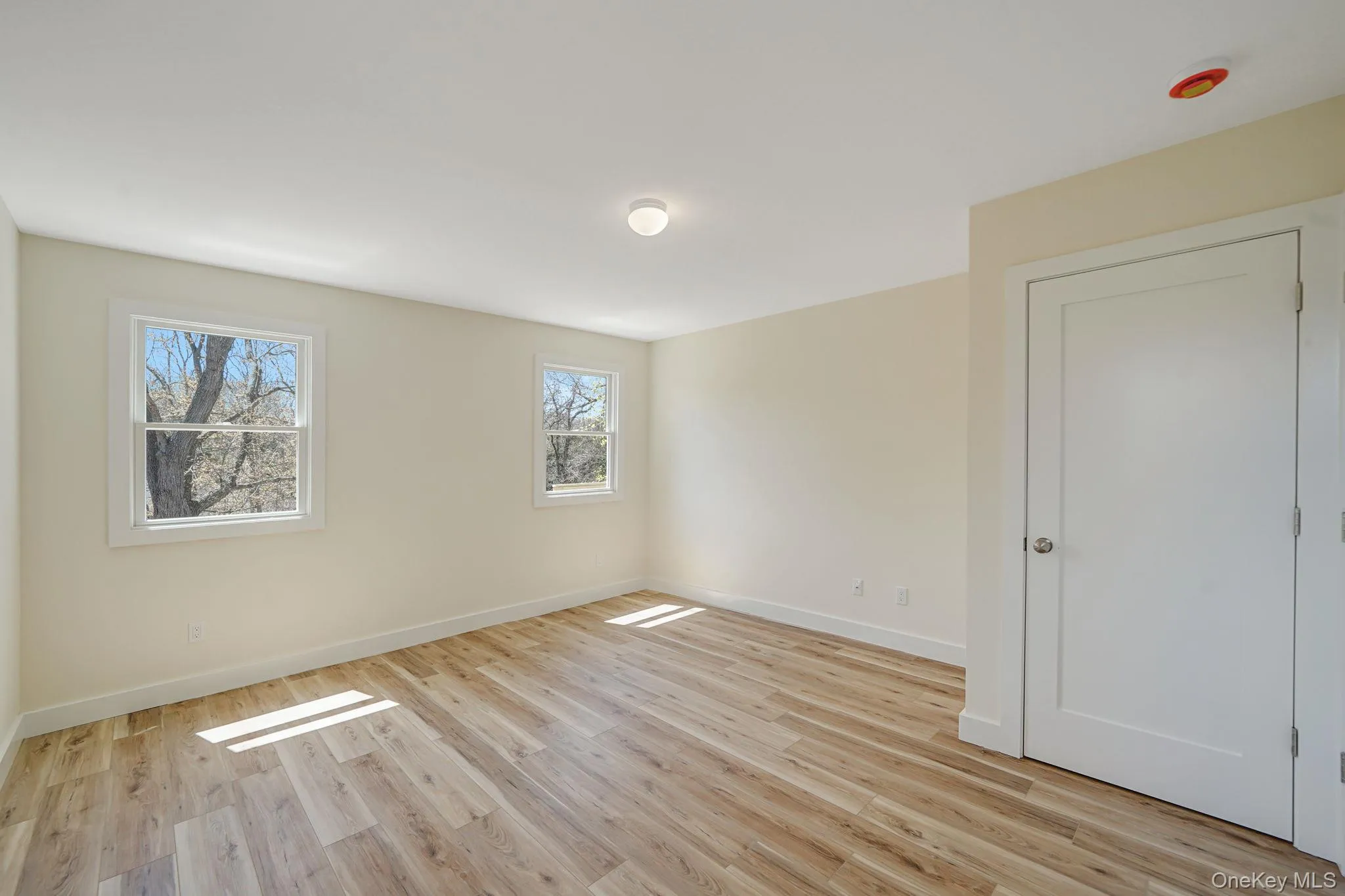 Empty room featuring light wood-style flooring and baseboards Empty room featuring light wood-style flooring and baseboards