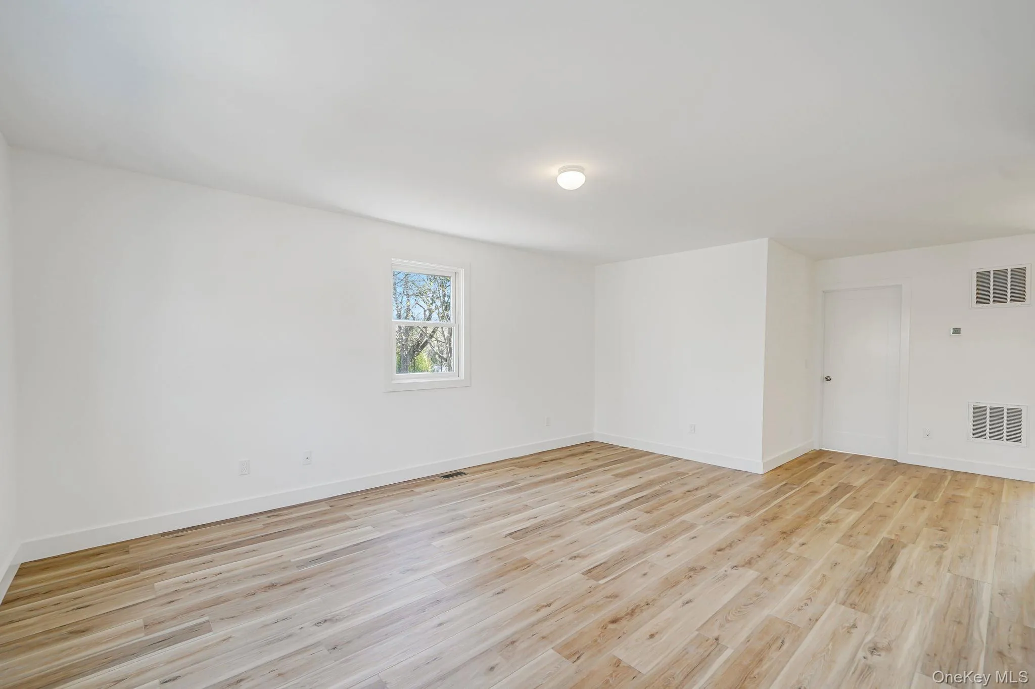 Empty room with light wood-type flooring and baseboards Empty room with light wood-type flooring and baseboards