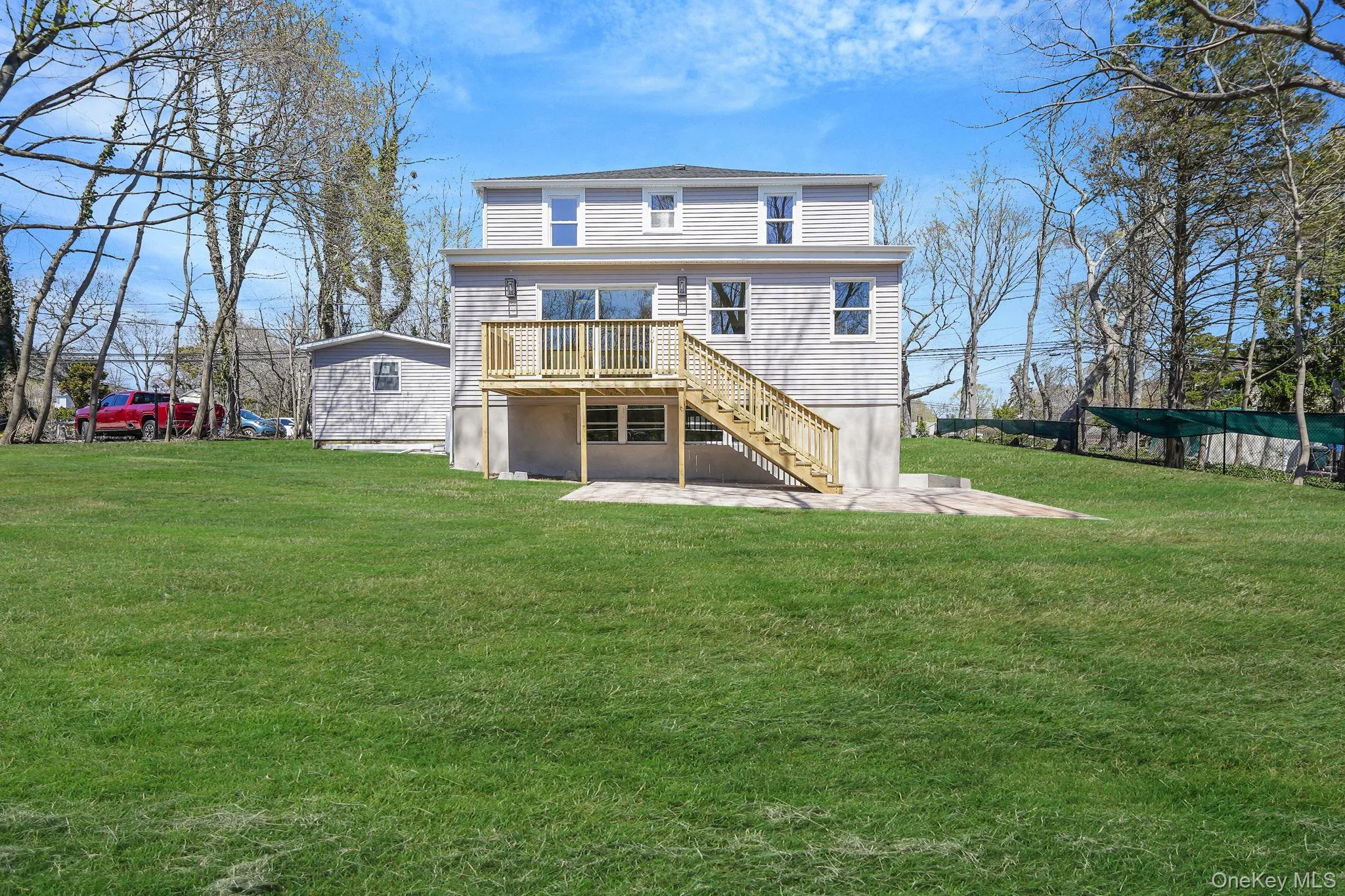 Rear view of house with a deck, stairs, a yard, and a patio area Rear view of house with a deck, stairs, a yard, and a patio area
