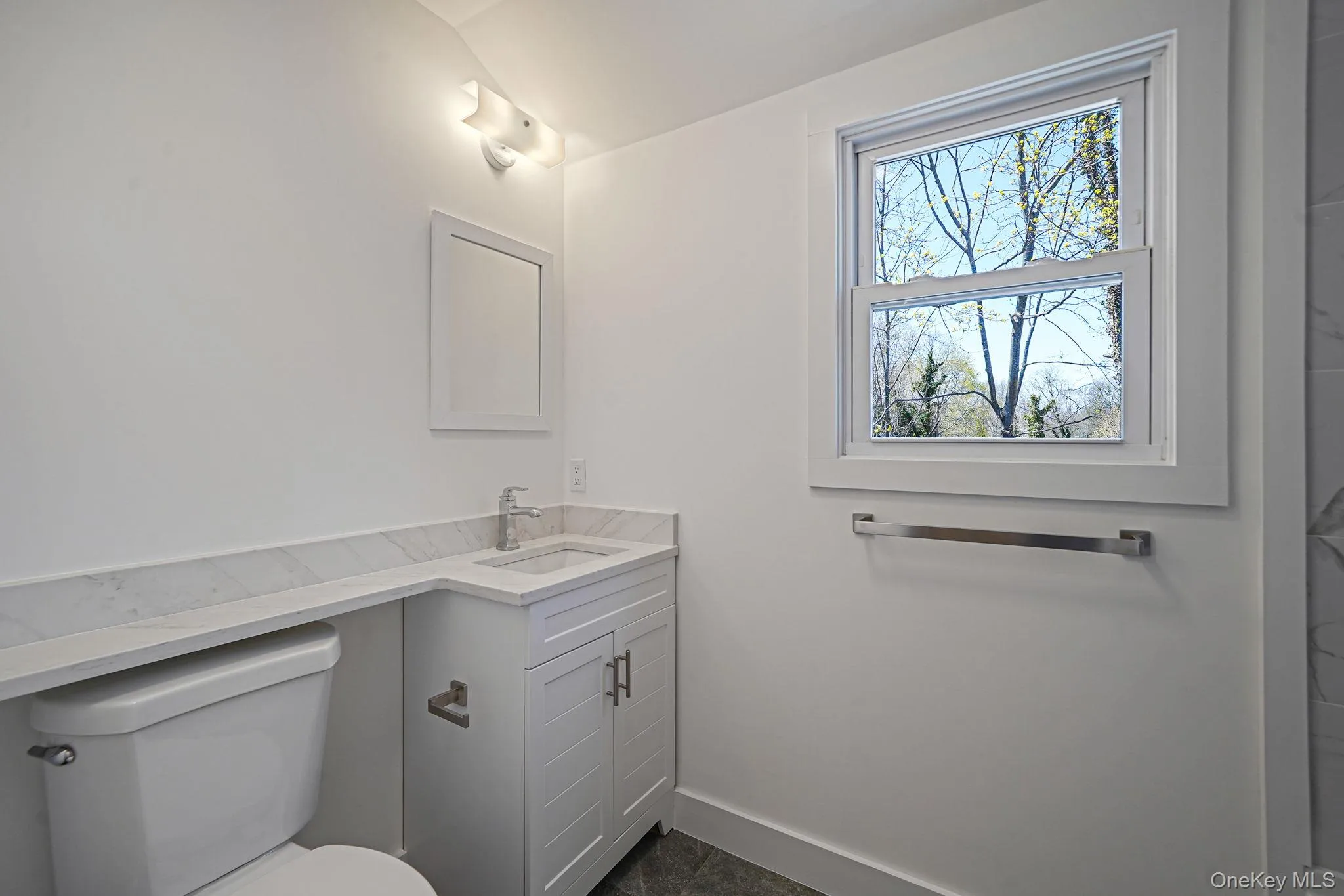 Bathroom with toilet, vanity, and baseboards Bathroom with toilet, vanity, and baseboards