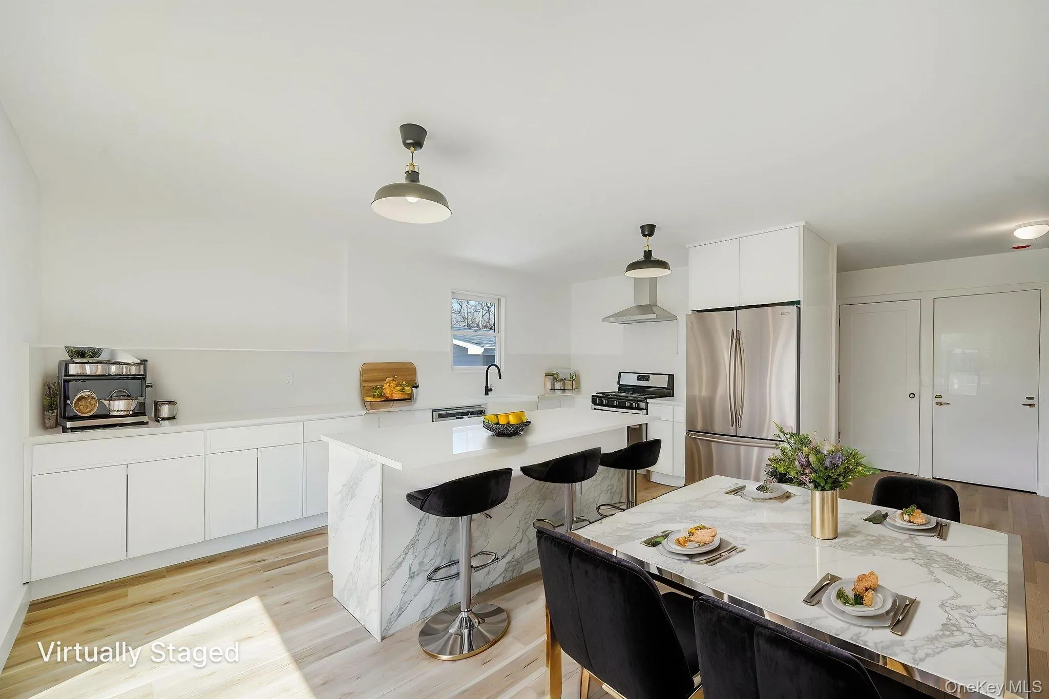 Kitchen featuring stainless steel appliances, modern cabinets, a kitchen breakfast bar, white cabinetry, and pendant lighting Kitchen featuring stainless steel appliances, modern cabinets, a kitchen breakfast bar, white cabinetry, and pendant lighting