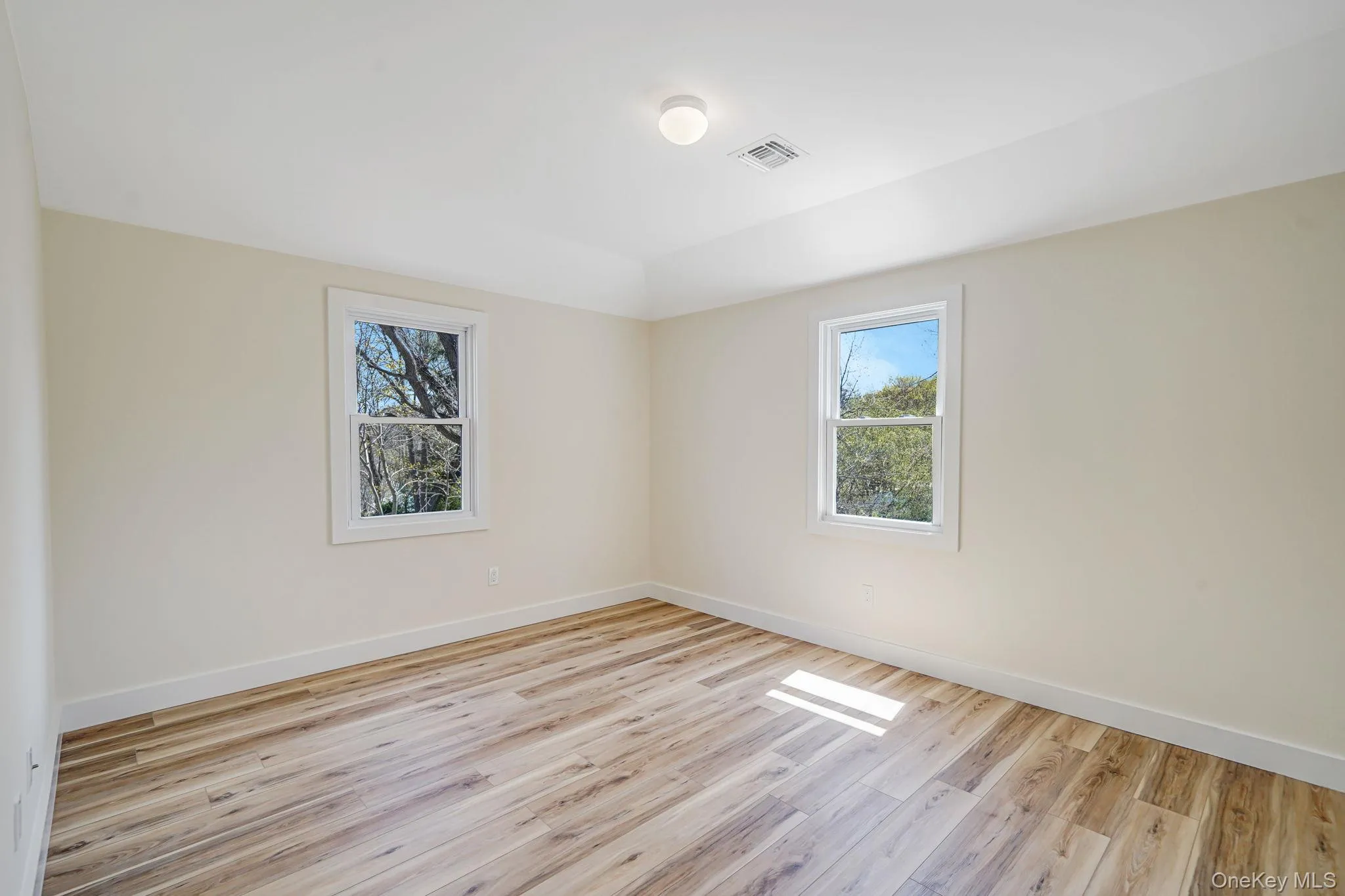 Empty room with healthy amount of natural light, light wood-type flooring, and baseboards Empty room with healthy amount of natural light, light wood-type flooring, and baseboards