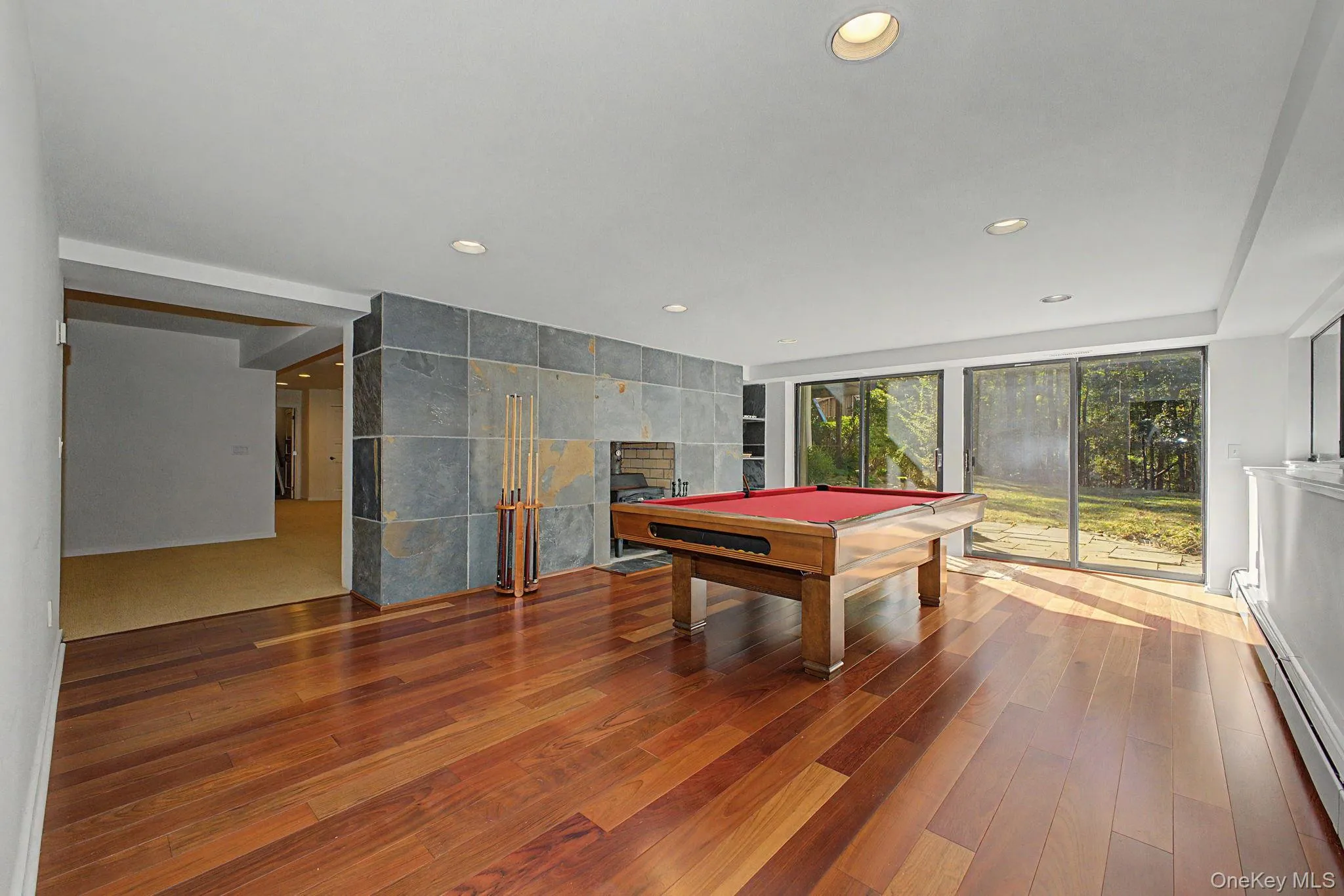Billiard room with fireplace and sliding doors to a patio. Billiard room with fireplace and sliding doors to a patio.