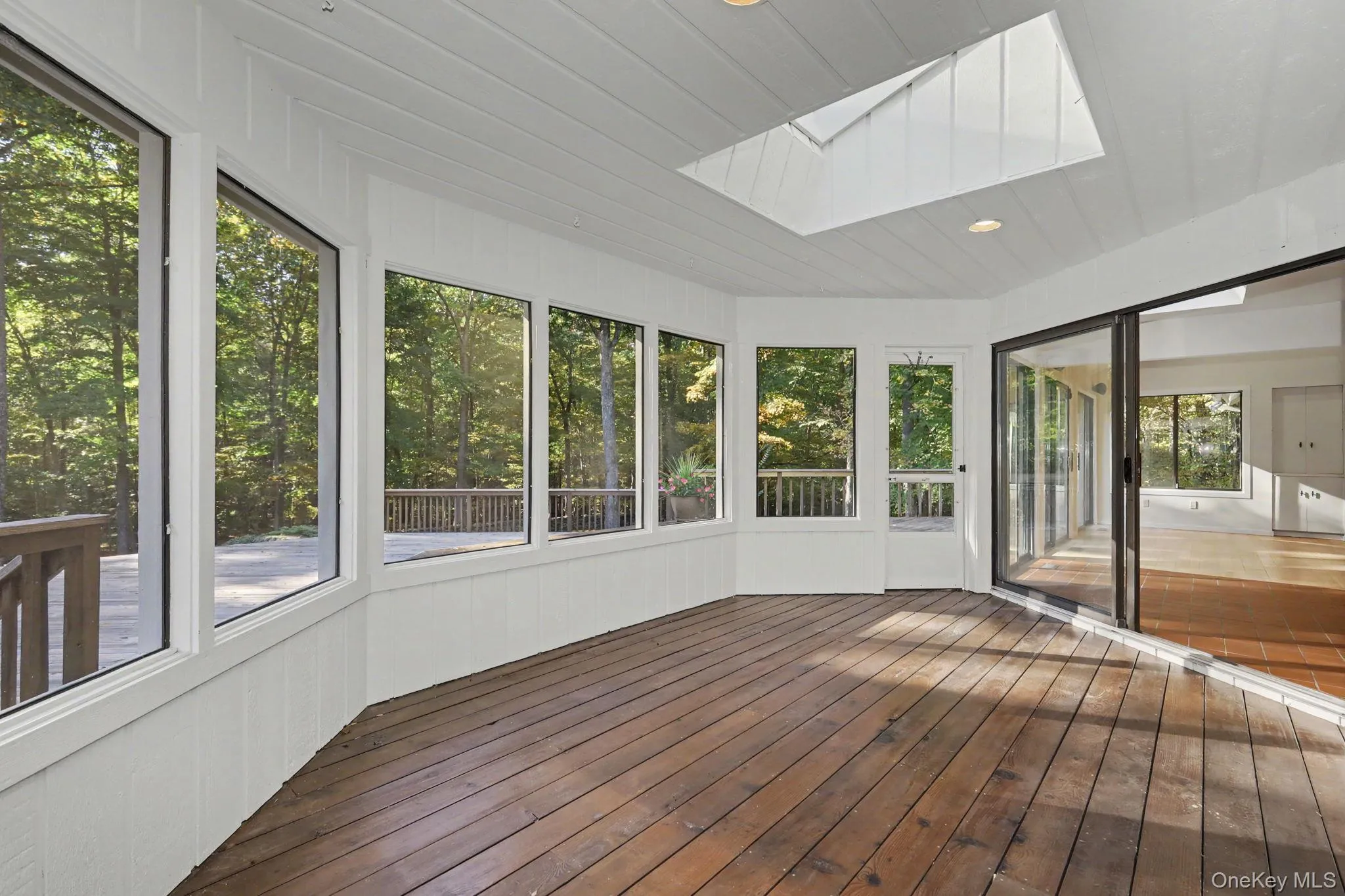 Screened porch with skylight and peaceful woodland views, accessible from the kitchen-dining area and deck. Screened porch with skylight and peaceful woodland views, accessible from the kitchen-dining area and deck.