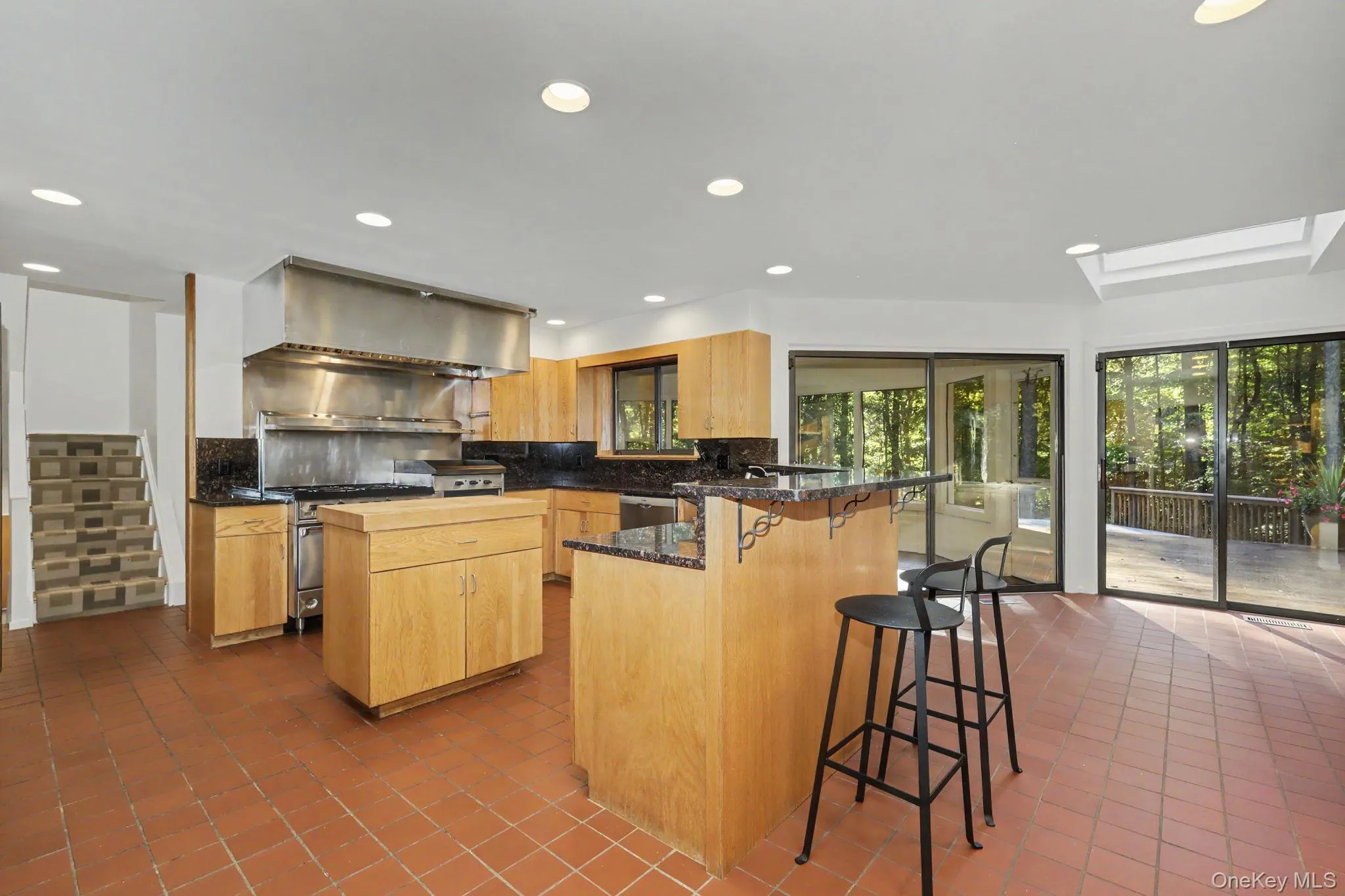 Light-filled kitchen with a center prep island and adjoining dining area with sliding glass doors to the screened-in porch and deck. Light-filled kitchen with a center prep island and adjoining dining area with sliding glass doors to the screened-in porch and deck.