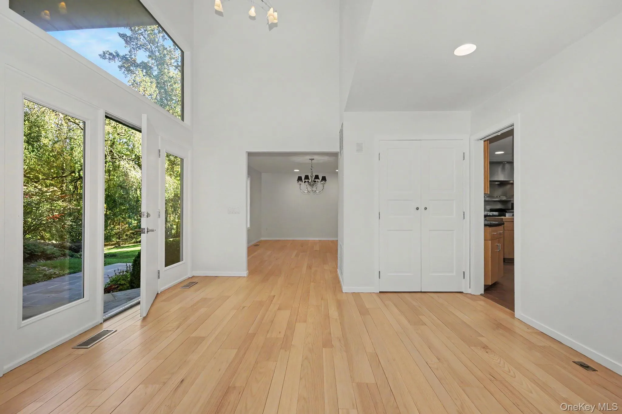 Spacious, light-filled entry foyer with high ceilings, expansive windows, and newly refinished hardwood floors. Spacious, light-filled entry foyer with high ceilings, expansive windows, and newly refinished hardwood floors.
