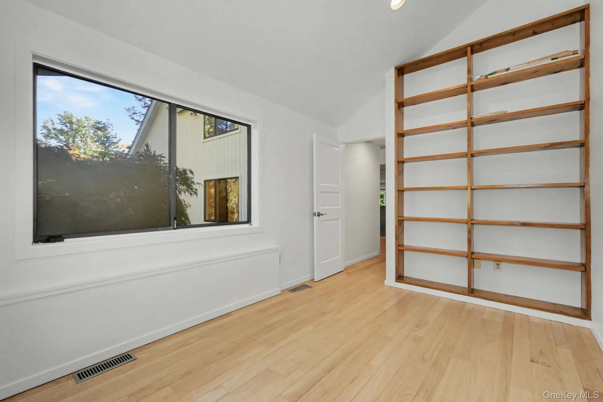 Private office with built-in shelving, large wrap-around windows, and direct access to the primary suite. Private office with built-in shelving, large wrap-around windows, and direct access to the primary suite.