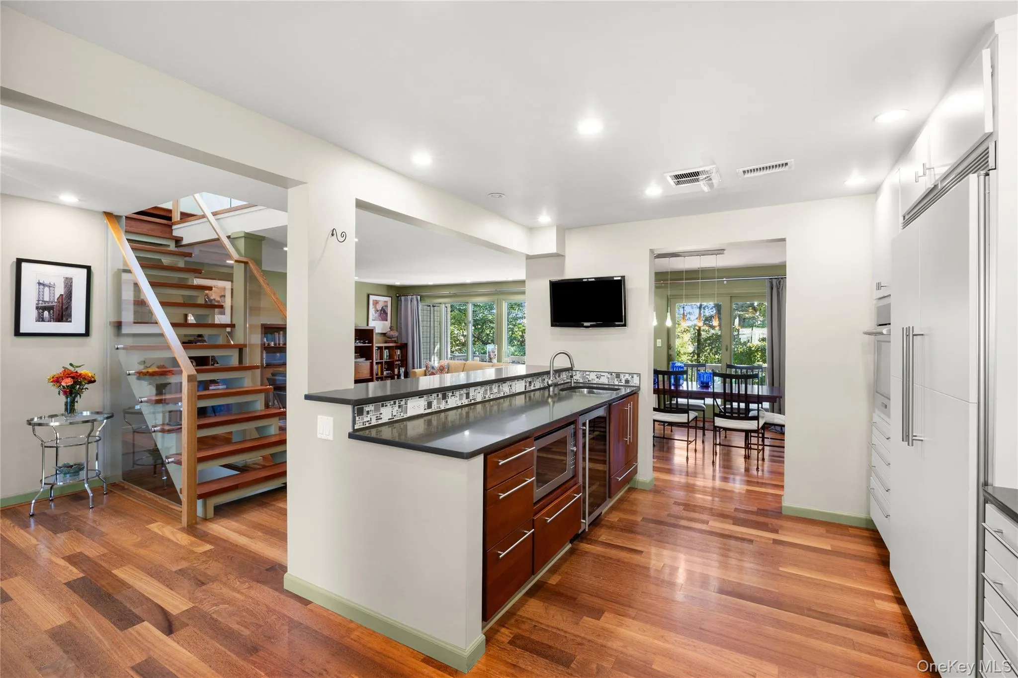 Kitchen peninsula features quartz countertops, wine bar and prep sink Kitchen peninsula features quartz countertops, wine bar and prep sink