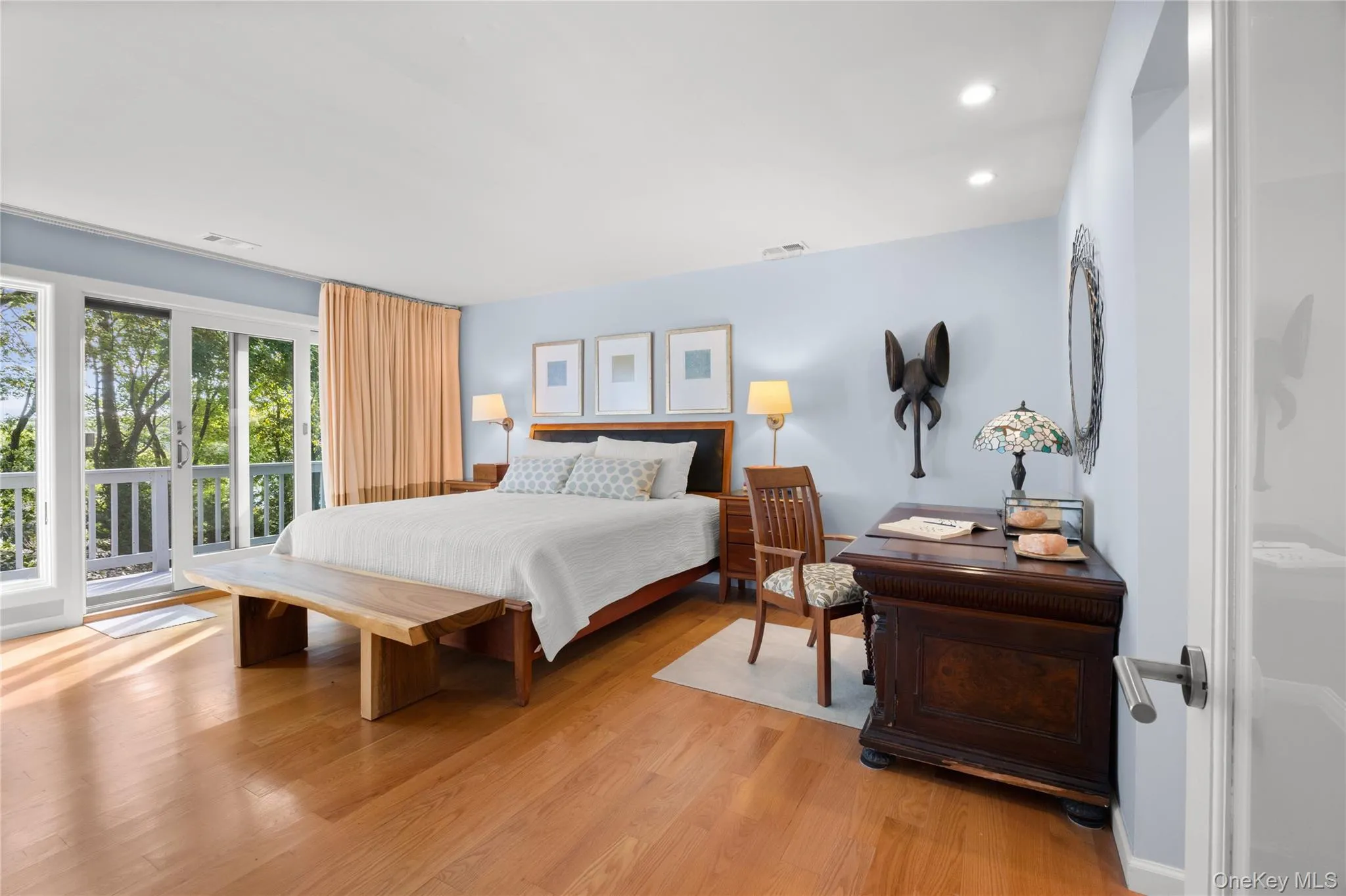 Primary bedroom with sliding glass doors leading to second story deck with winter waterviews Primary bedroom with sliding glass doors leading to second story deck with winter waterviews