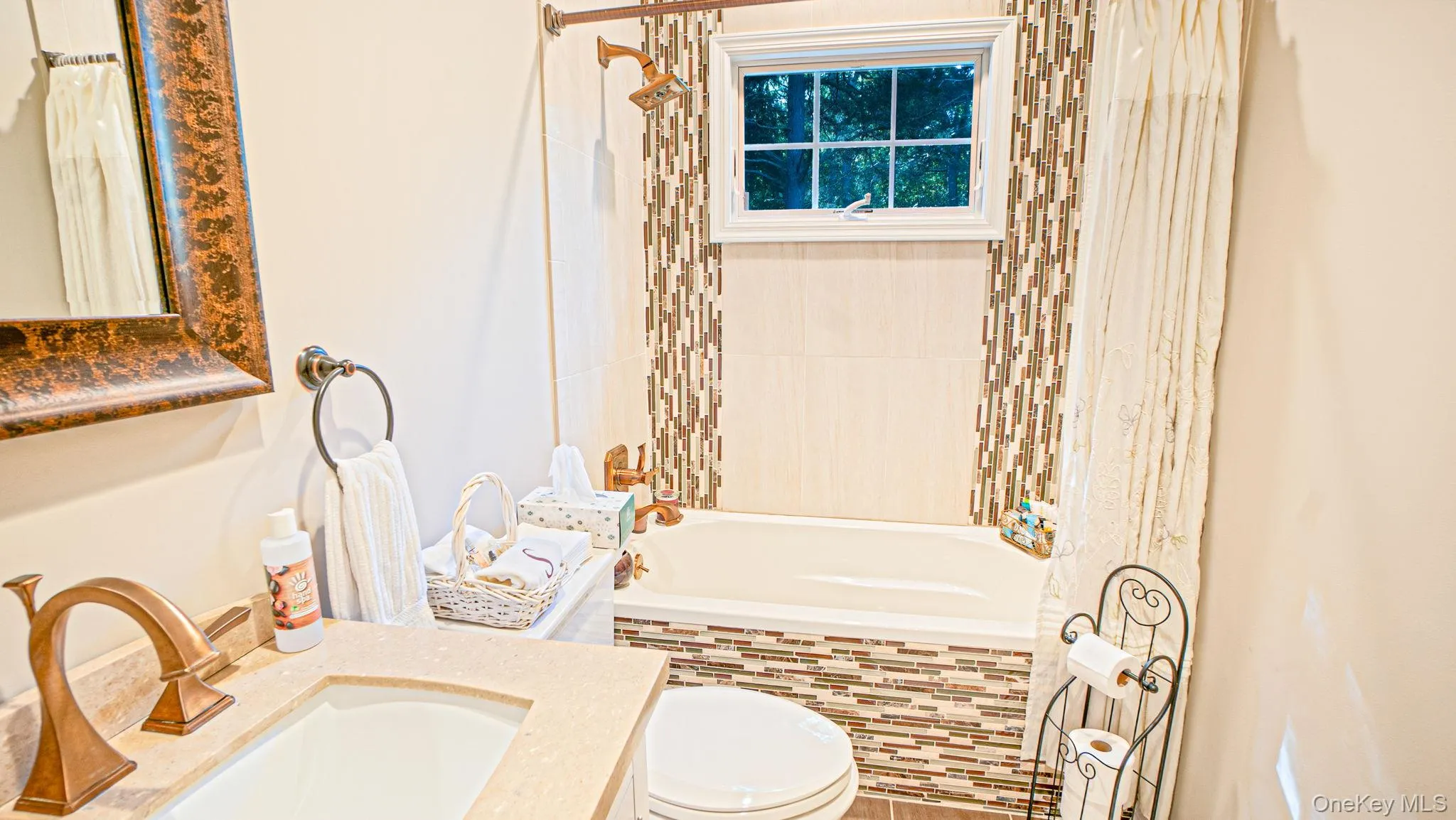 Single sink vanity, Tub/shower, bronze-finish fixtures, and mosaic tile accents -radiant heated floors Single sink vanity, Tub/shower, bronze-finish fixtures, and mosaic tile accents -radiant heated floors