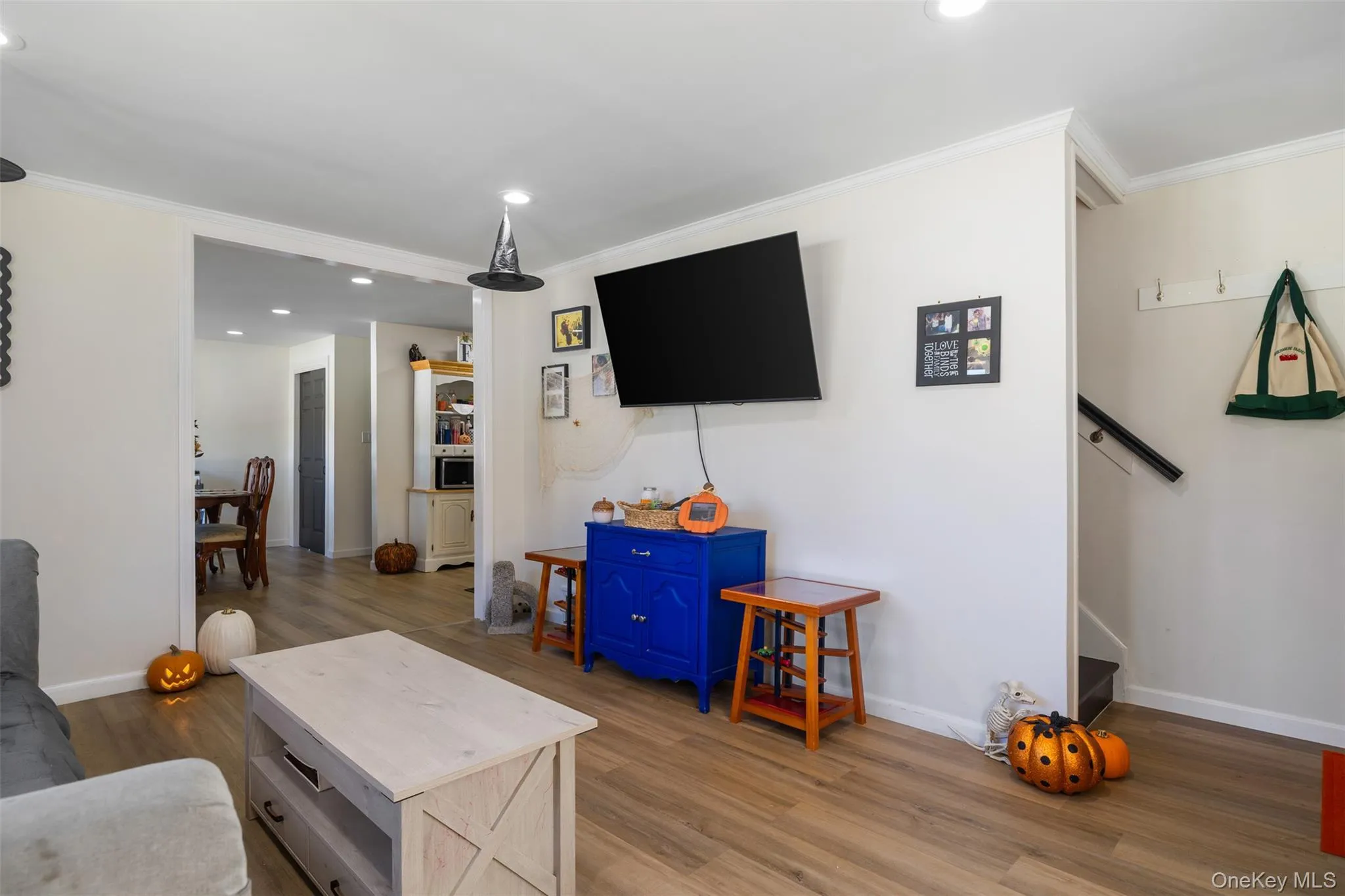 Wood-finish flooring throughout, recessed ceiling lighting, crown molding, and an open entryway to an additional room Wood-finish flooring throughout, recessed ceiling lighting, crown molding, and an open entryway to an additional room