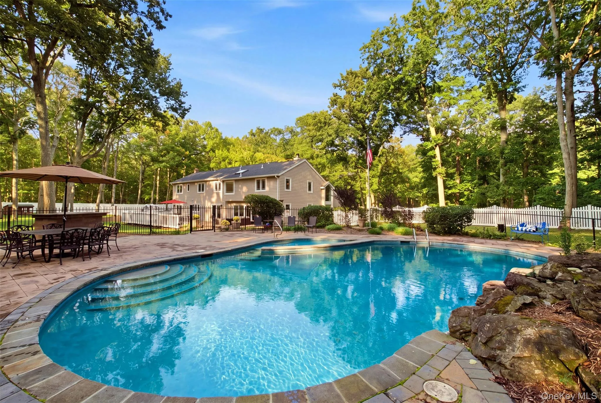 Poolside bar has granite top with a sink and refrigerator Poolside bar has granite top with a sink and refrigerator