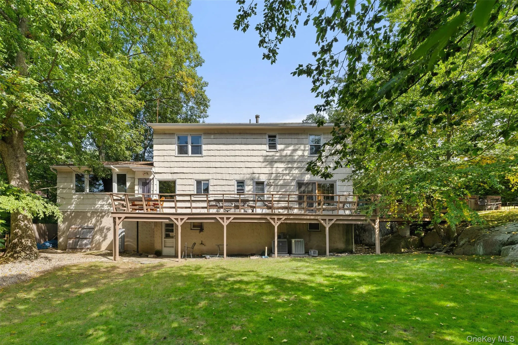 Expansive backyard with a manicured lawn, multi-level wood deck, and mature trees. Expansive backyard with a manicured lawn, multi-level wood deck, and mature trees.