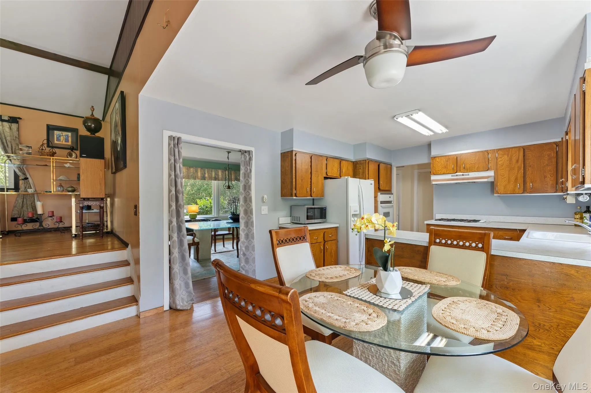 Kitchen featuring wood cabinetry, solid surface countertops, and a ceiling fan. Kitchen featuring wood cabinetry, solid surface countertops, and a ceiling fan.