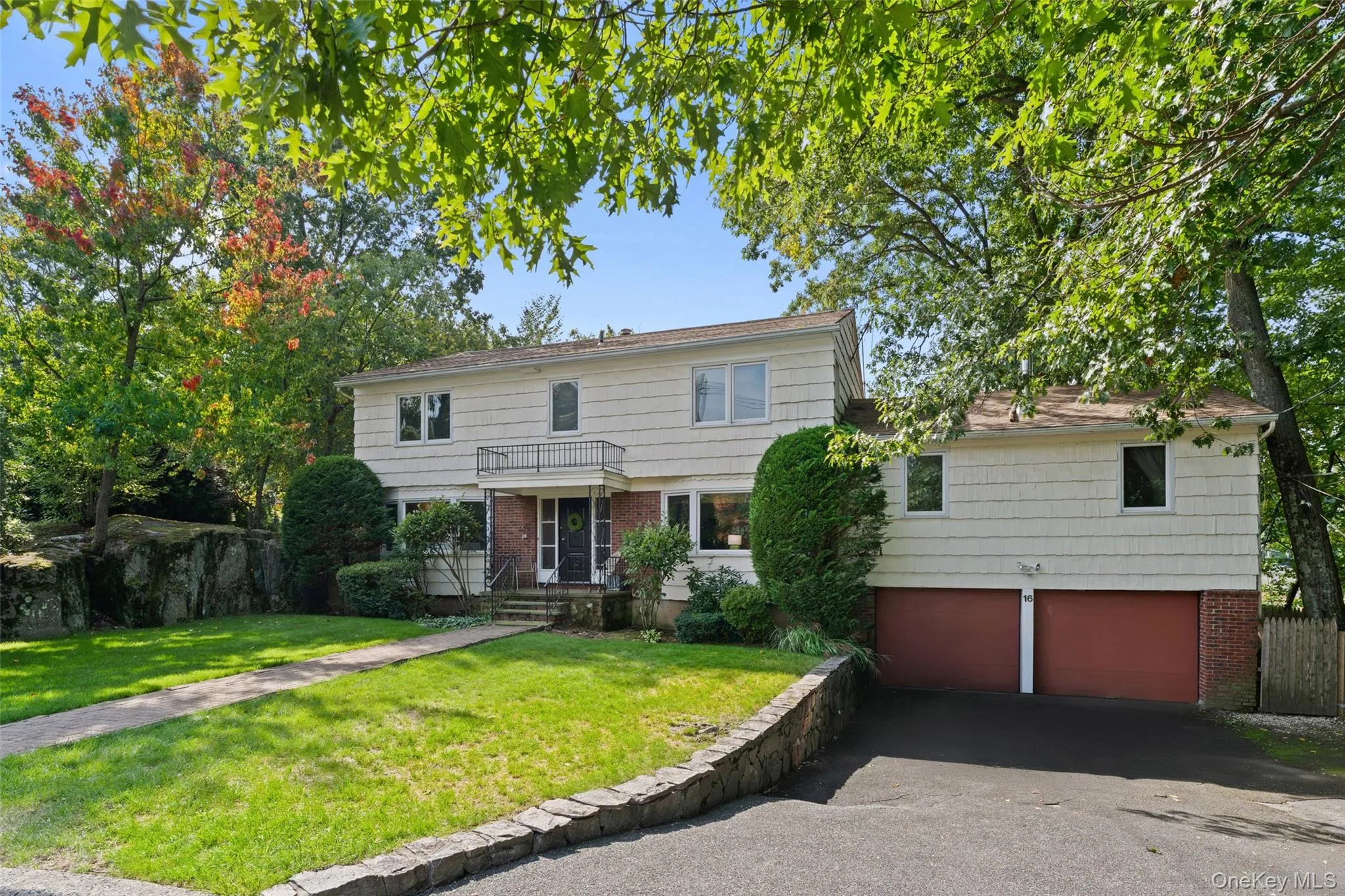 Welcome to 16 Cadillac Drive. Two-story residence with a brick paver walkway, mature trees, and a front lawn. Welcome to 16 Cadillac Drive. Two-story residence with a brick paver walkway, mature trees, and a front lawn.