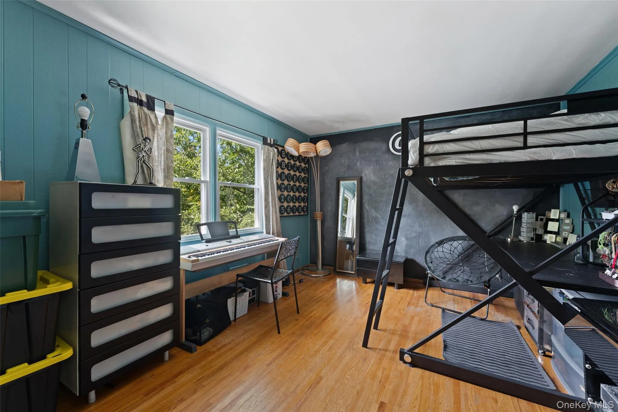 Hardwood flooring with a white ceiling and teal panel walls. Hardwood flooring with a white ceiling and teal panel walls.