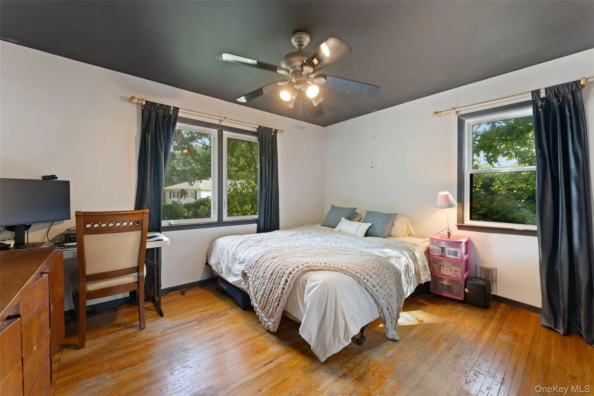 Hardwood flooring, painted white walls, dark-painted ceiling, and a ceiling fan. Hardwood flooring, painted white walls, dark-painted ceiling, and a ceiling fan.
