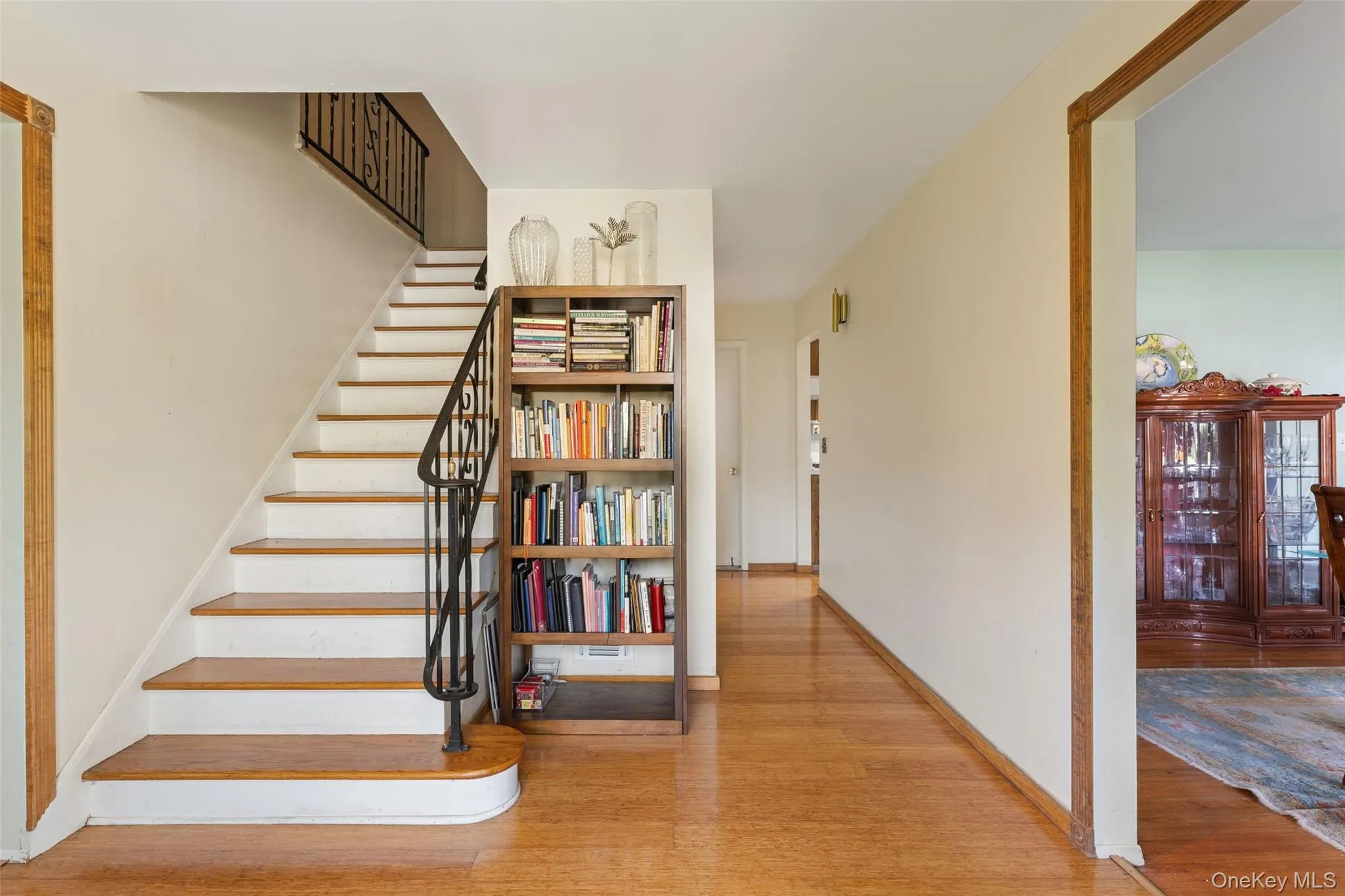 Entryway featuring hardwood flooring and a staircase with wrought iron railing. Entryway featuring hardwood flooring and a staircase with wrought iron railing.