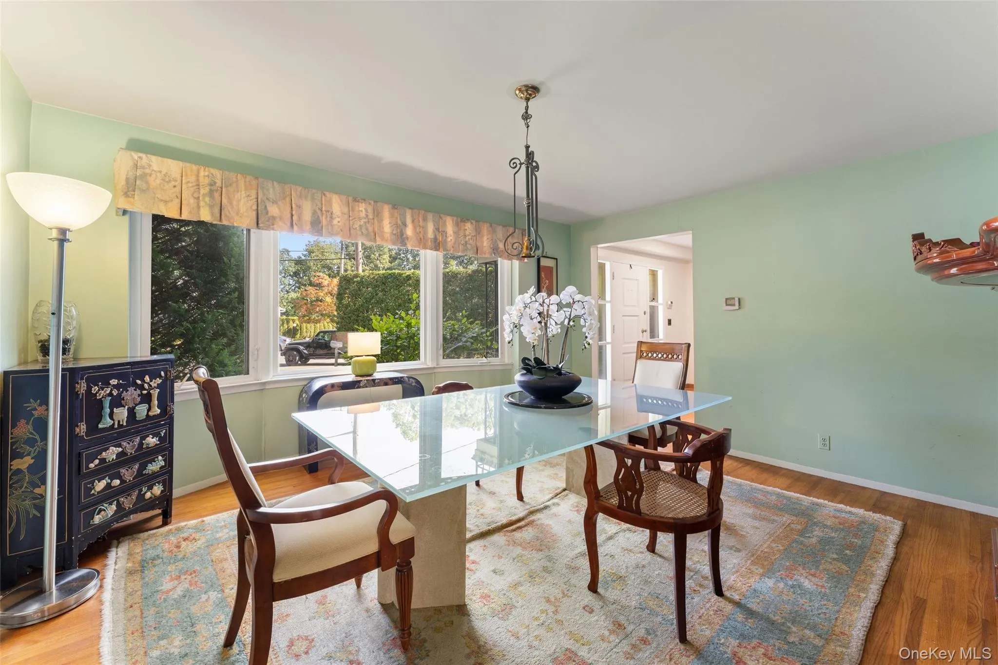 Hardwood flooring, broad window with valance, and a ceiling light fixture. Hardwood flooring, broad window with valance, and a ceiling light fixture.