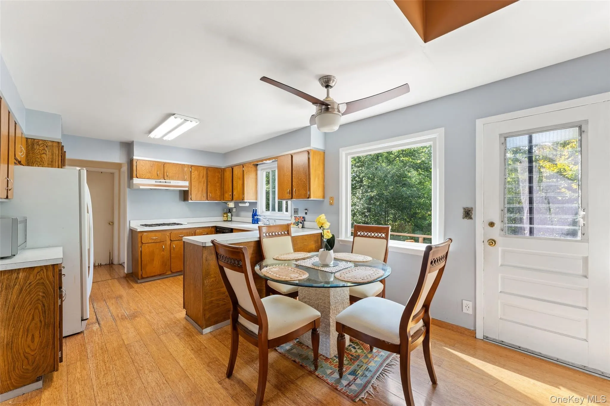 Kitchen featuring wood cabinetry, solid surface countertops, and a ceiling fan. Kitchen featuring wood cabinetry, solid surface countertops, and a ceiling fan.