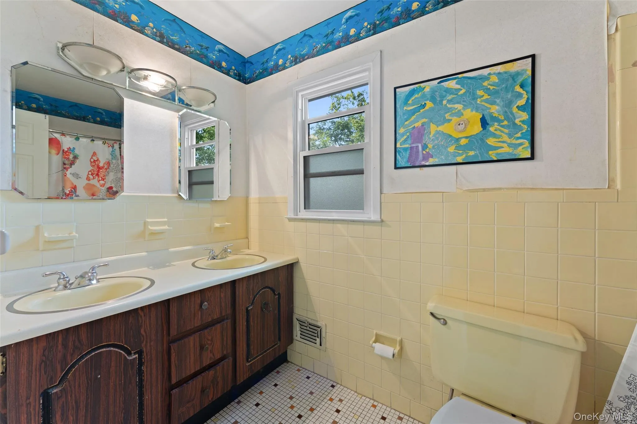 Vanity with two sinks, wood-finish cabinetry, and overhead lighting. Vanity with two sinks, wood-finish cabinetry, and overhead lighting.