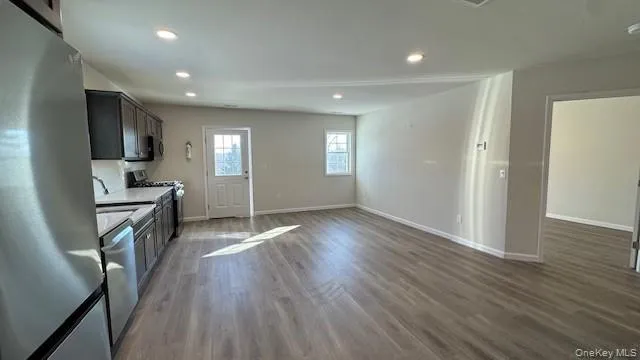 Kitchen with dark hardwood / wood-style flooring, sink, and appliances with stainless steel finishes Kitchen with dark hardwood / wood-style flooring, sink, and appliances with stainless steel finishes