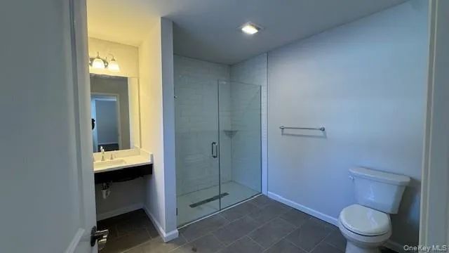 Bathroom with sink, toilet, walk in shower, and tile patterned floors Bathroom with sink, toilet, walk in shower, and tile patterned floors