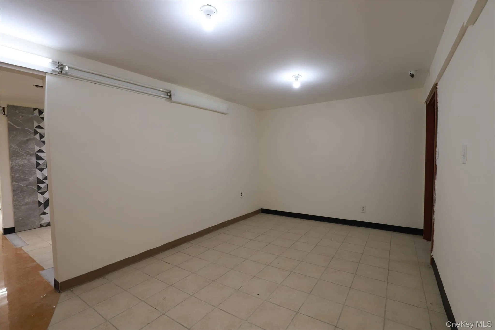 Tile flooring, recessed lighting, and a sliding door track Tile flooring, recessed lighting, and a sliding door track