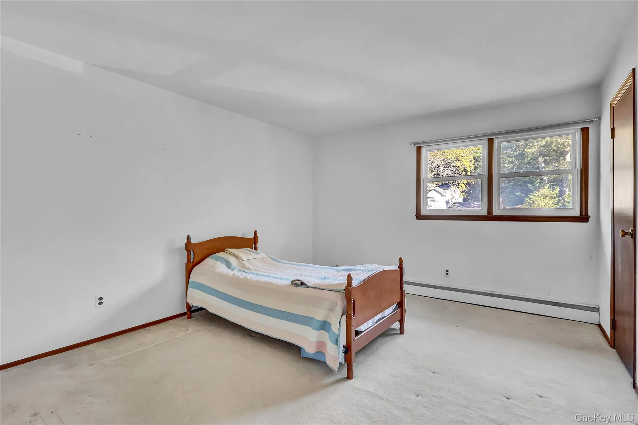 Neutral-toned wall finish, dual-pane window with wood-trim casing, and light-toned wall-to-wall carpeting Neutral-toned wall finish, dual-pane window with wood-trim casing, and light-toned wall-to-wall carpeting