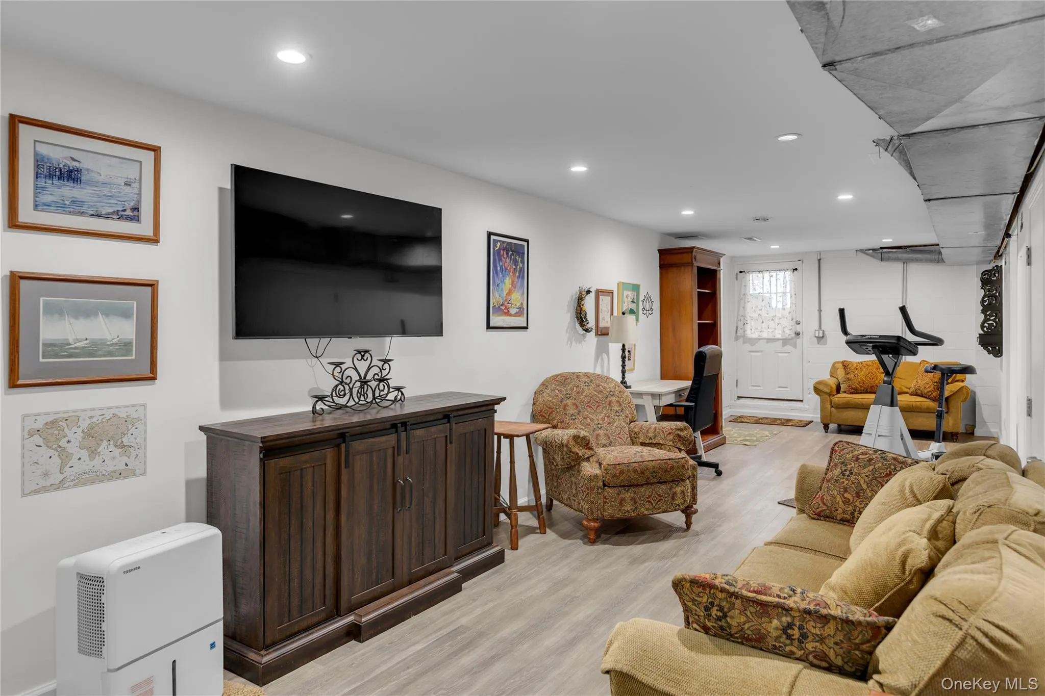 Recessed lighting, wood-finish flooring, white walls, built-in shelving, and a white paneled door Recessed lighting, wood-finish flooring, white walls, built-in shelving, and a white paneled door