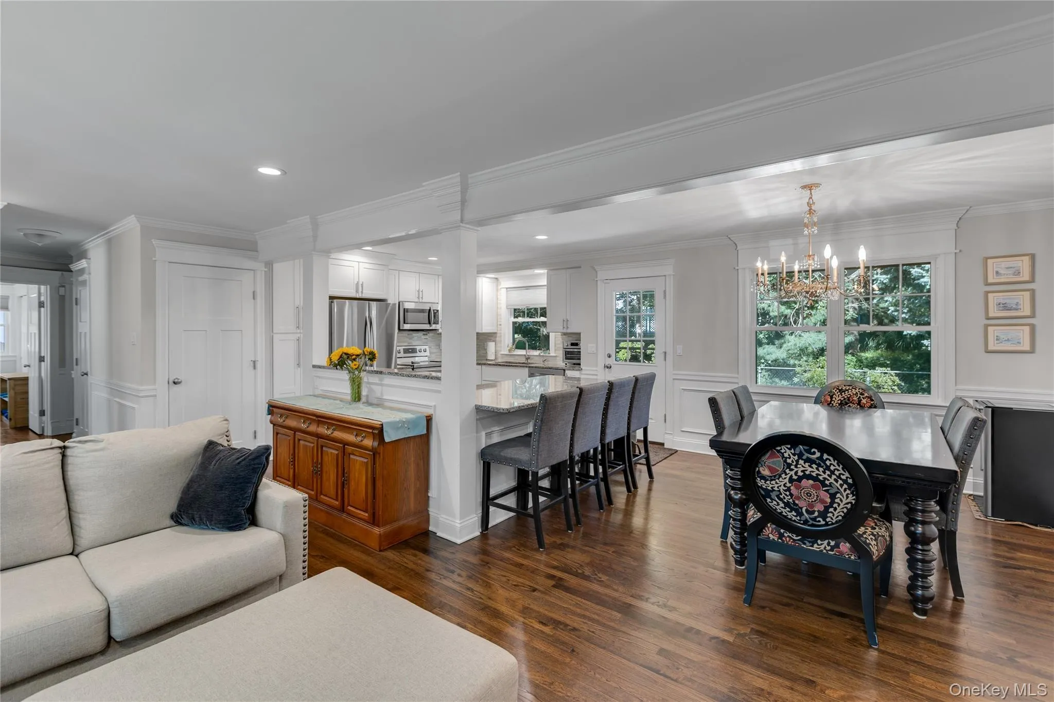 Hardwood-finish flooring throughout, recessed lighting, crown molding, kitchen island with seating, and a decorative chandelier Hardwood-finish flooring throughout, recessed lighting, crown molding, kitchen island with seating, and a decorative chandelier