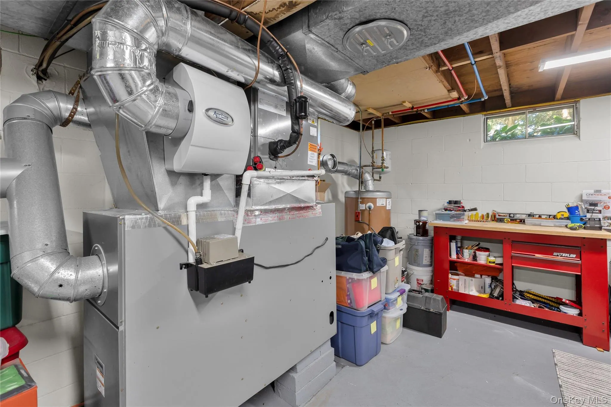 HVAC system with attached humidifier, water heater, and a workbench with storage HVAC system with attached humidifier, water heater, and a workbench with storage