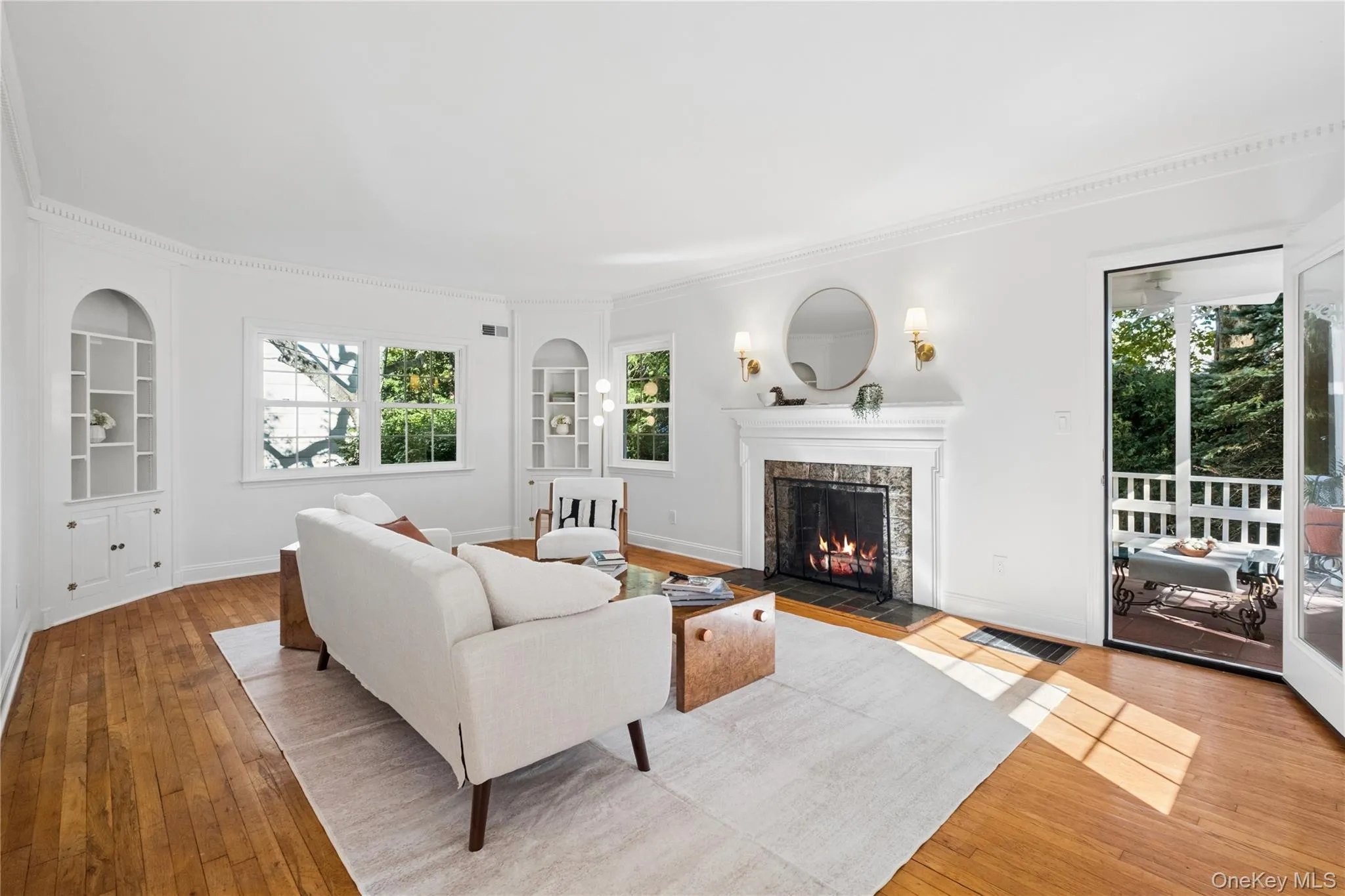 Living room with 2 built in corner cabinets, wood burning fireplace and door to covered outdoor patio Living room with 2 built in corner cabinets, wood burning fireplace and door to covered outdoor patio
