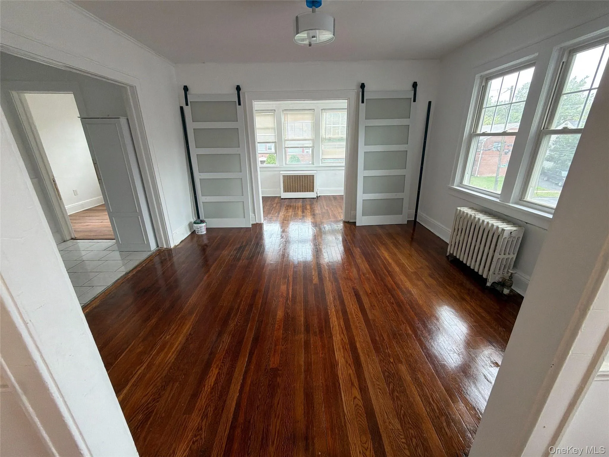 Dining room Hardwood flooring throughout, with white walls and trim, and multiple windows providing natural illumination Dining room Hardwood flooring throughout, with white walls and trim, and multiple windows providing natural illumination