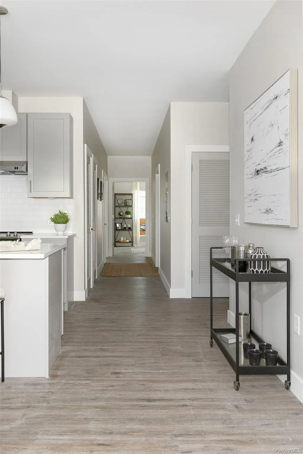Kitchen featuring light gray cabinetry and white subway tile backsplash Kitchen featuring light gray cabinetry and white subway tile backsplash