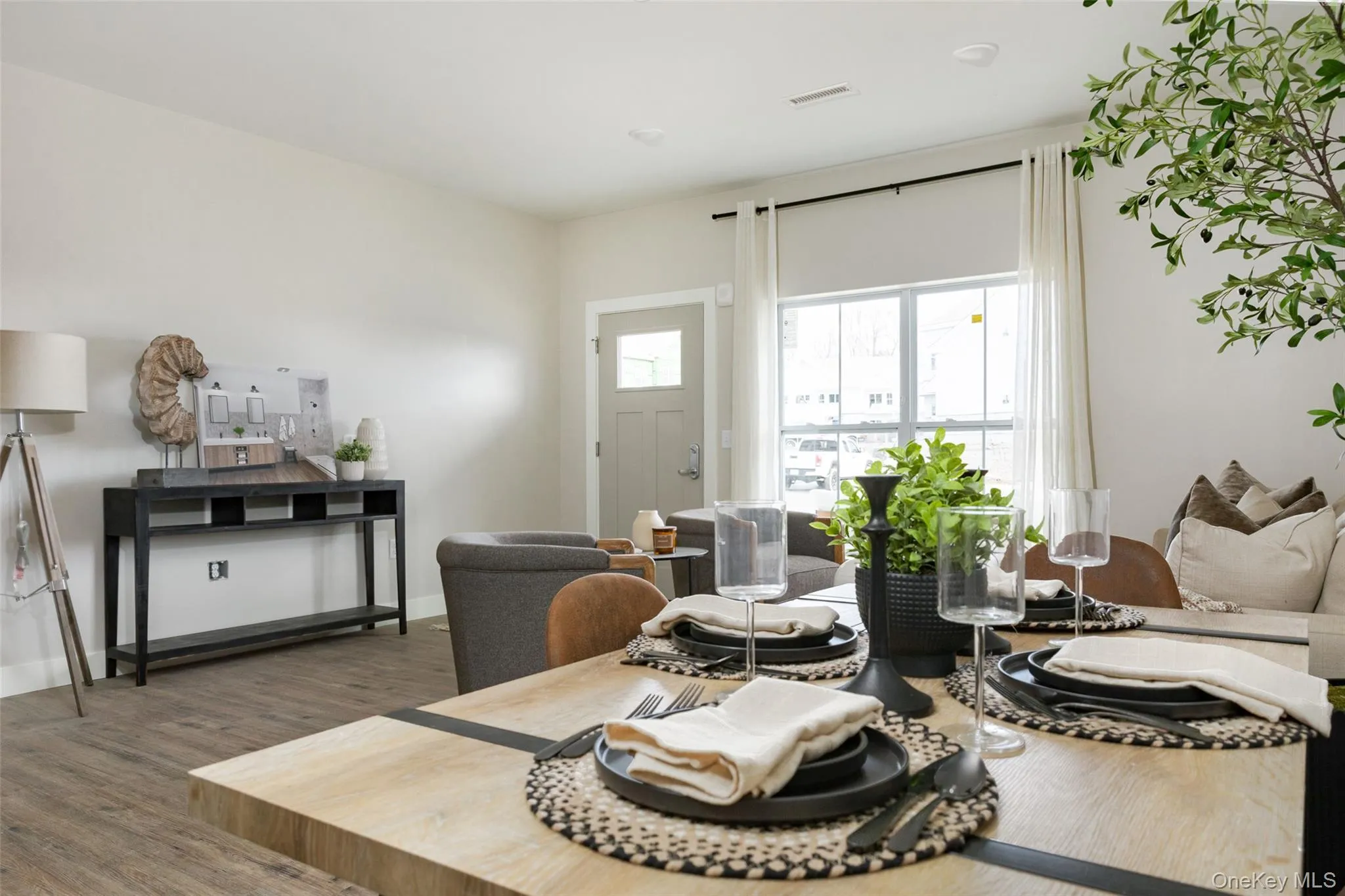Wood-finish flooring throughout the main living area, recessed lighting, and a white paneled door with a transom window. Wood-finish flooring throughout the main living area, recessed lighting, and a white paneled door with a transom window.