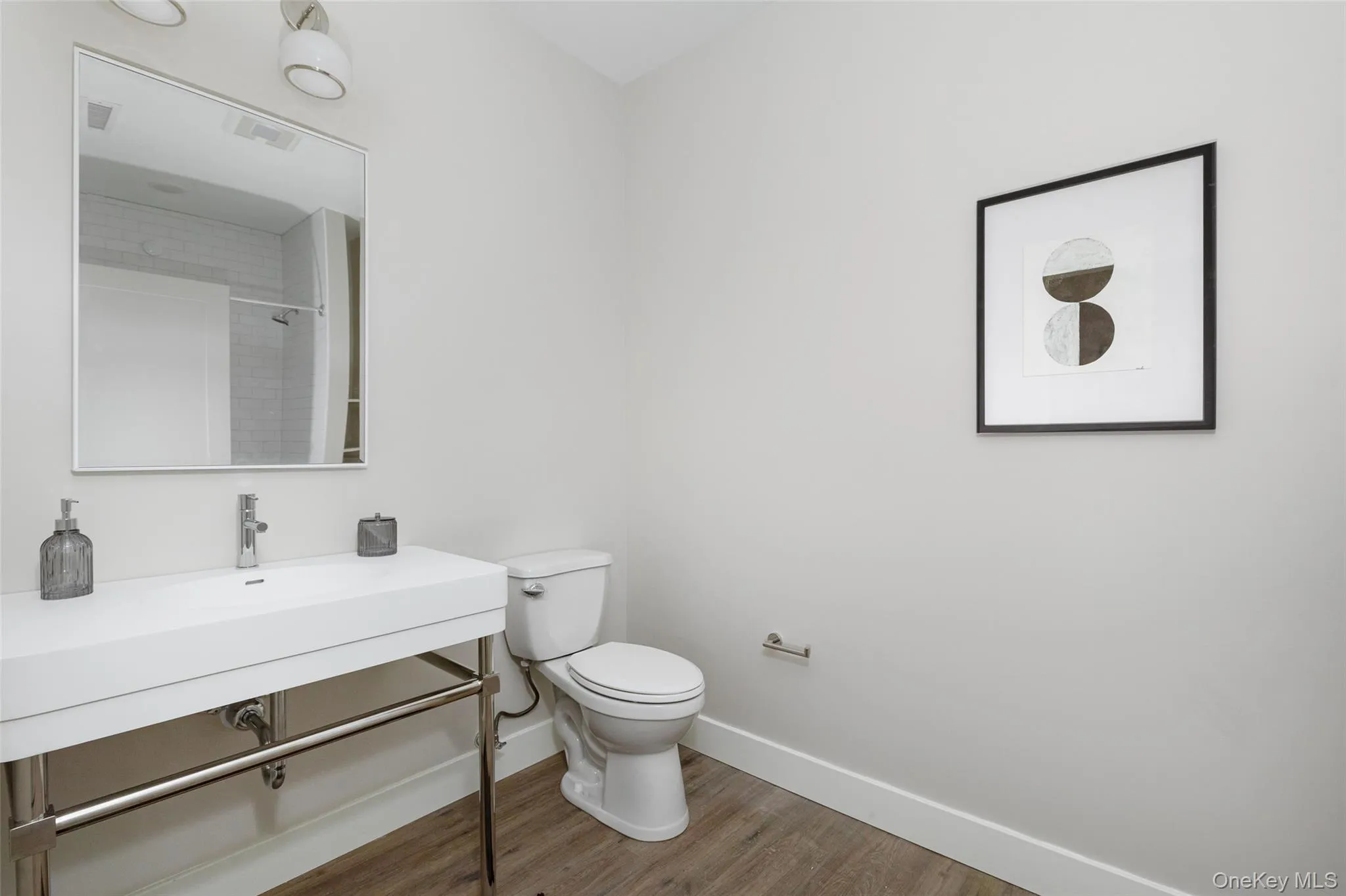 Second full-size bathroom with vanity with an integrated rectangular sink, chrome faucet, and exposed chrome-finish plumbing Second full-size bathroom with vanity with an integrated rectangular sink, chrome faucet, and exposed chrome-finish plumbing