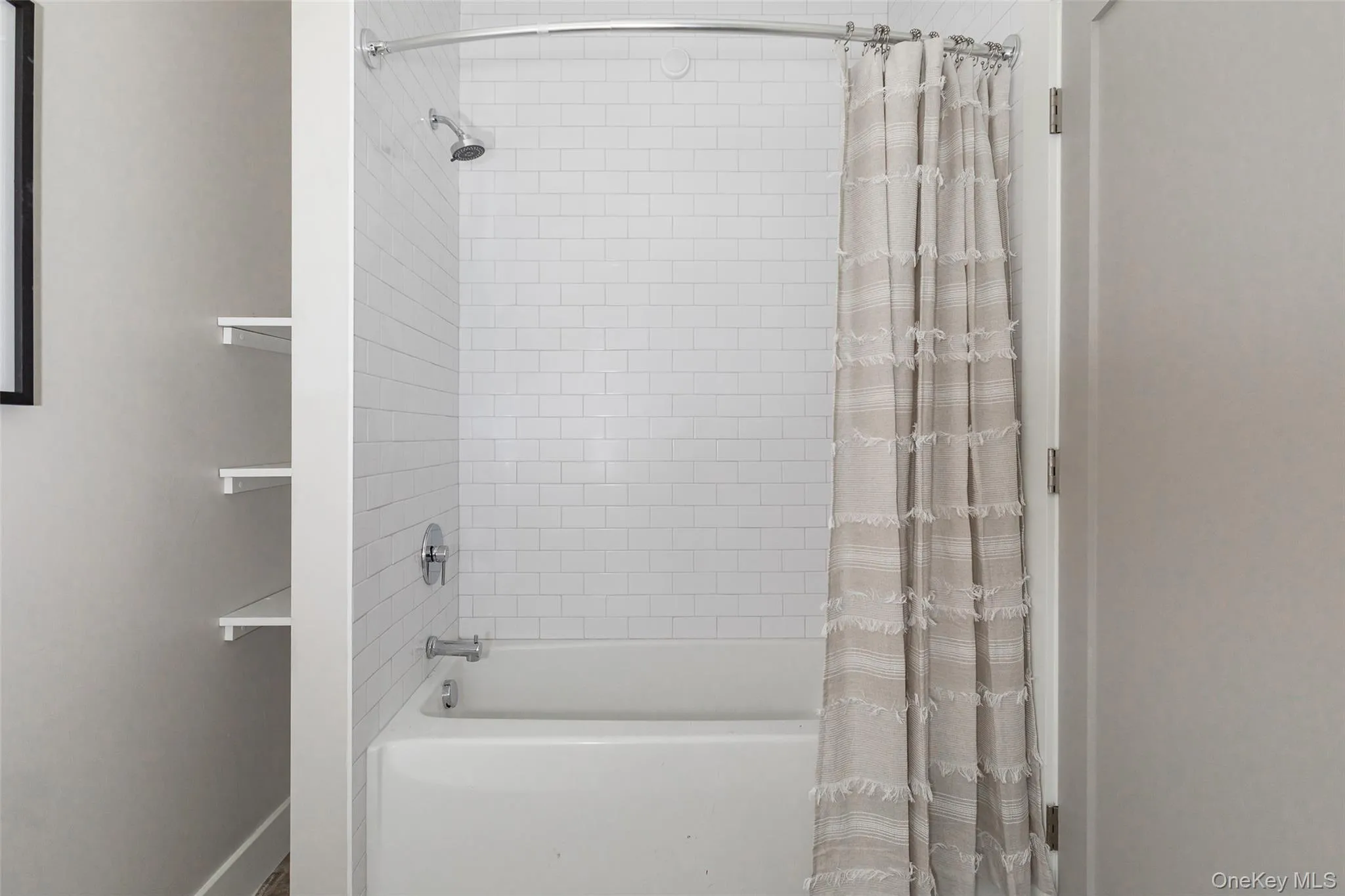 Second bathroom with white subway tile shower surround with chrome fixtures and built-in shelving. Second bathroom with white subway tile shower surround with chrome fixtures and built-in shelving.