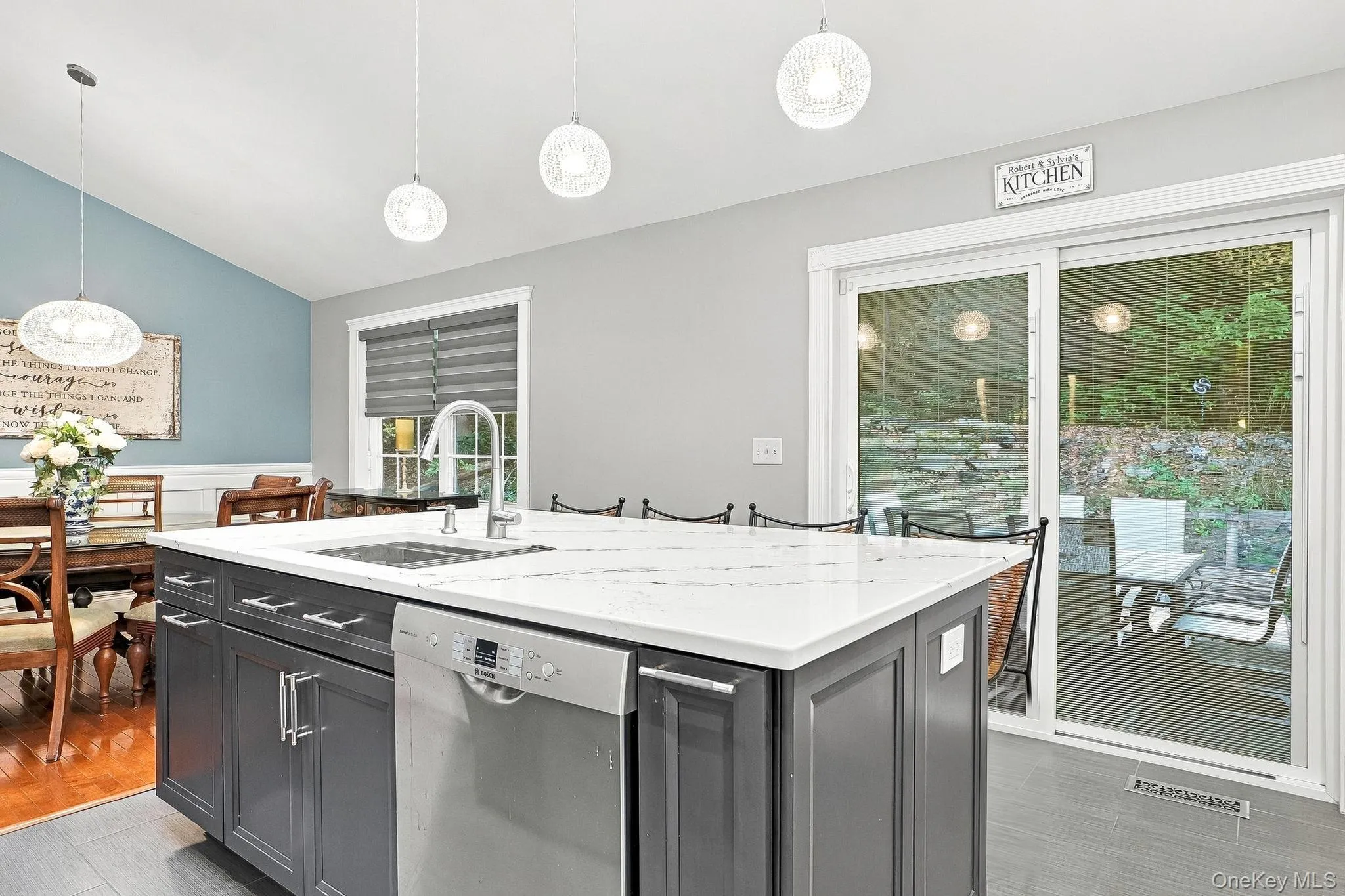 Kitchen island with white-veined countertop, integrated sink, and stainless steel dishwasher Kitchen island with white-veined countertop, integrated sink, and stainless steel dishwasher