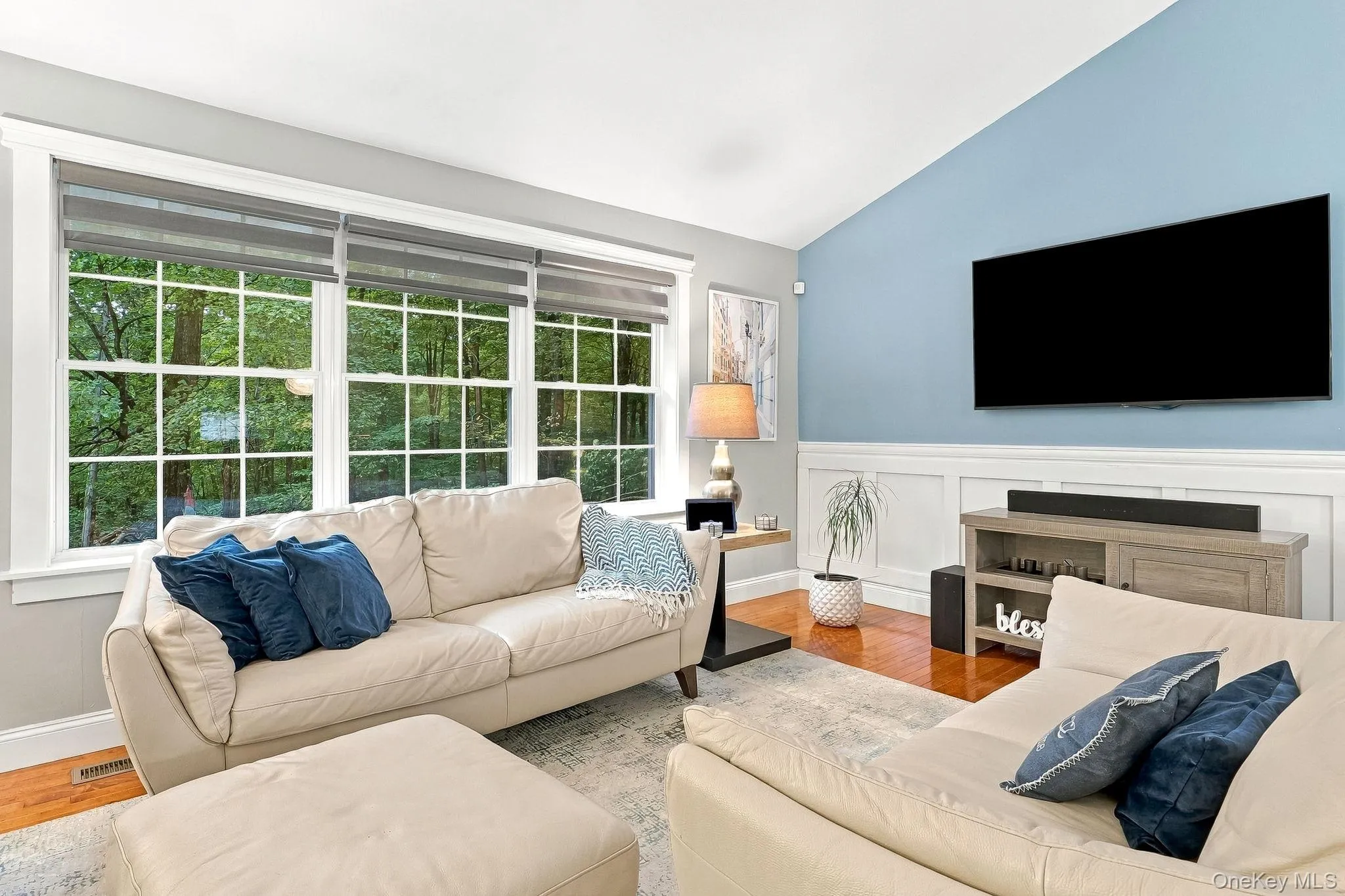 Vaulted ceiling, hardwood flooring, large multi-pane windows, decorative wainscoting, and a wall-mounted display space Vaulted ceiling, hardwood flooring, large multi-pane windows, decorative wainscoting, and a wall-mounted display space