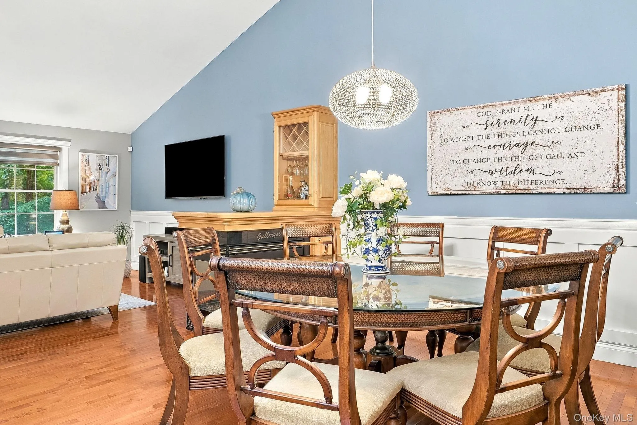 Vaulted ceiling, chair rail molding, wood-flooring, built-in cabinetry, and a decorative pendant light fixture Vaulted ceiling, chair rail molding, wood-flooring, built-in cabinetry, and a decorative pendant light fixture