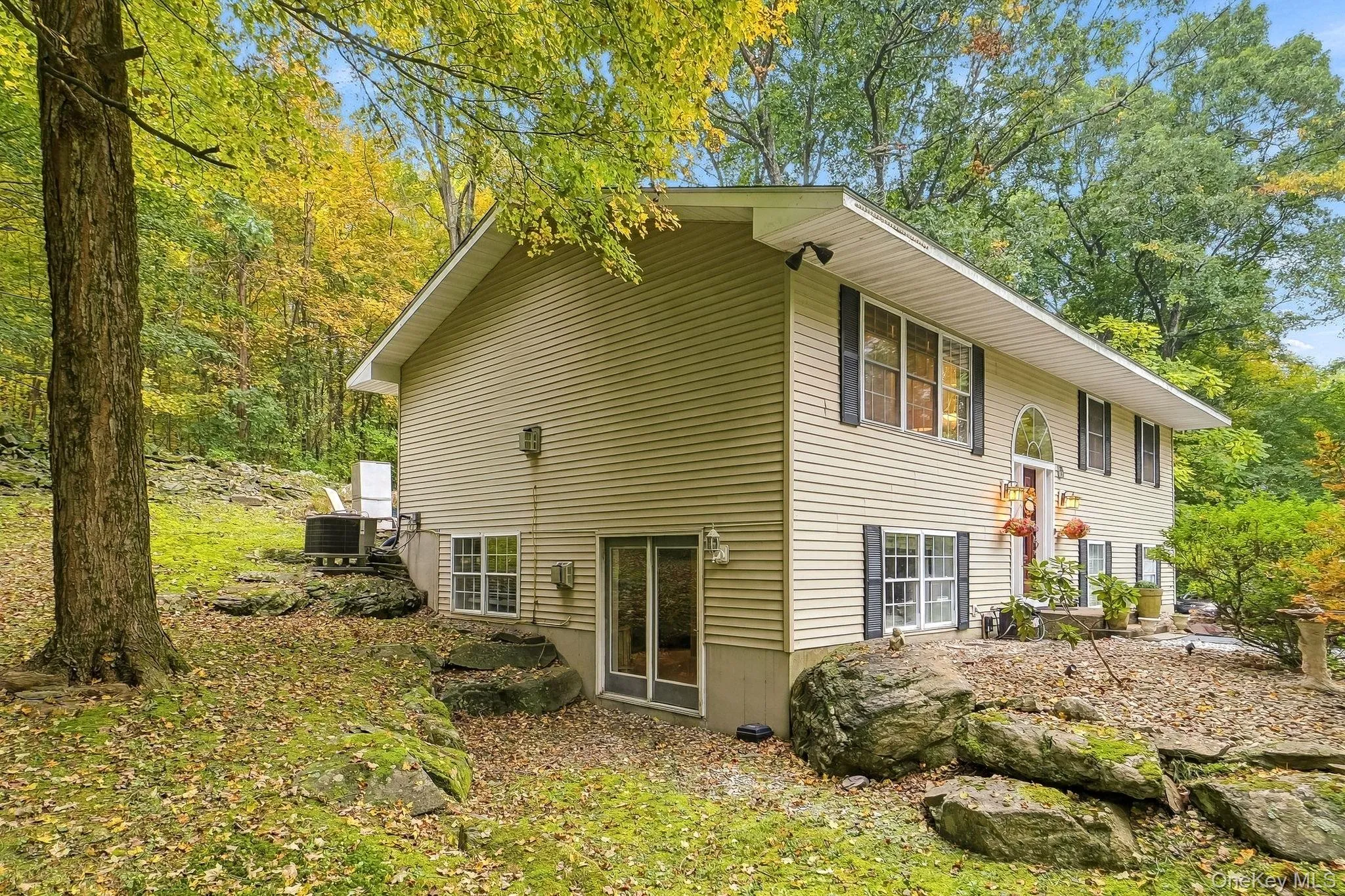 Two-story exterior with light-colored siding and dark window shutters Two-story exterior with light-colored siding and dark window shutters