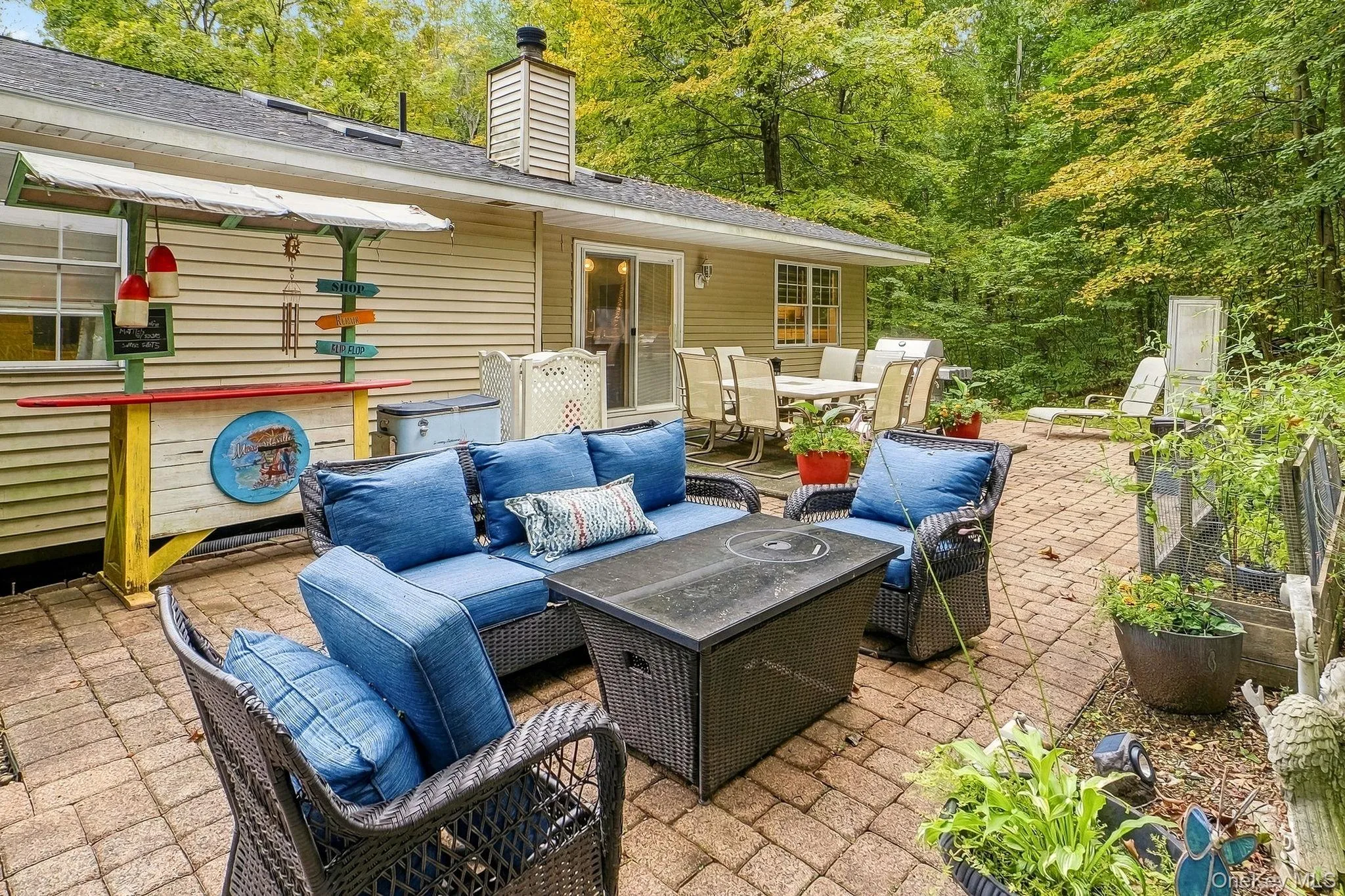 Expansive paver patio with a built-in outdoor Tiki bar and a large outdoor dining area Expansive paver patio with a built-in outdoor Tiki bar and a large outdoor dining area