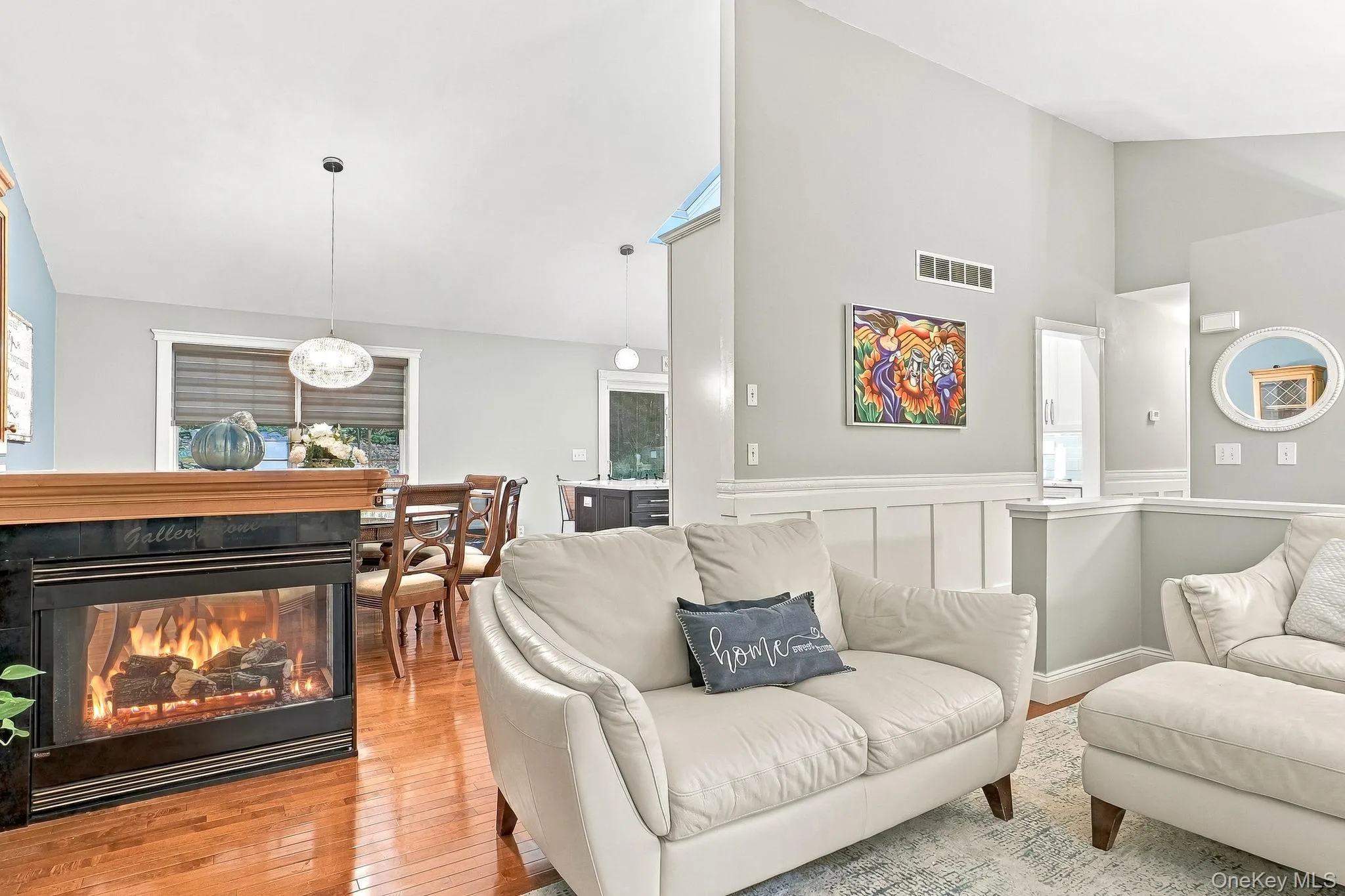 Hardwood flooring, a built-in fireplace with a stone and modern lighting Hardwood flooring, a built-in fireplace with a stone and modern lighting