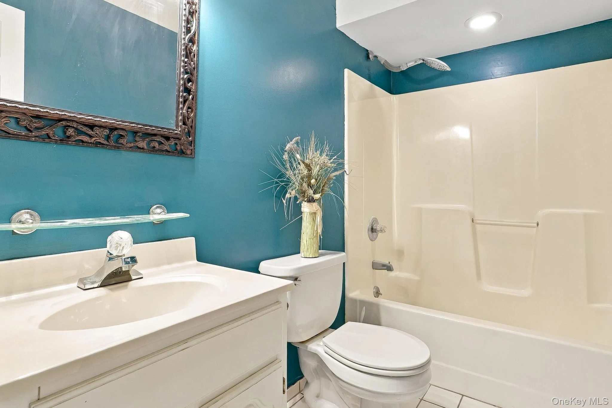Integrated vanity with a single basin sink, wall-mounted mirror, and tub/shower combination Integrated vanity with a single basin sink, wall-mounted mirror, and tub/shower combination
