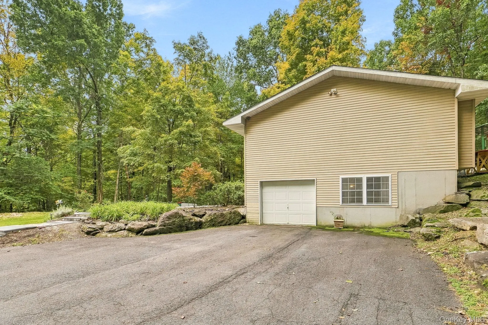 Siding exterior with a built-in garage and white garage door Siding exterior with a built-in garage and white garage door